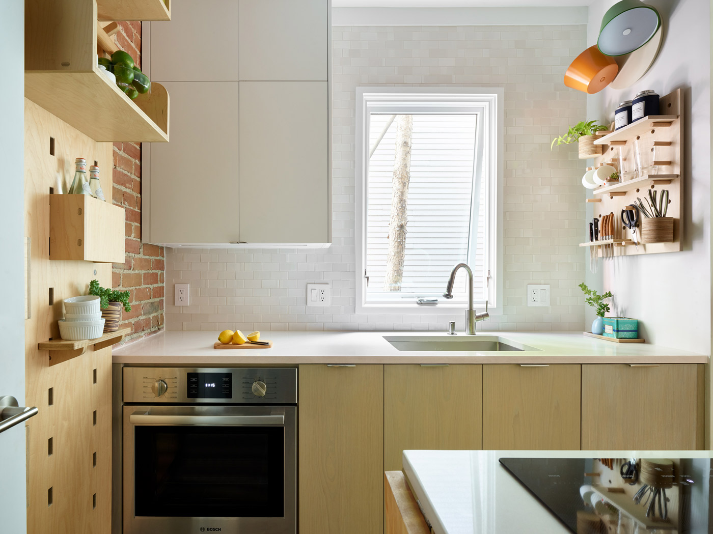 The tall bottom portion of the wall-hung cabinet helps emphasize the high ceilings. The cerused oak base cabinets have some silver tones in the grain.