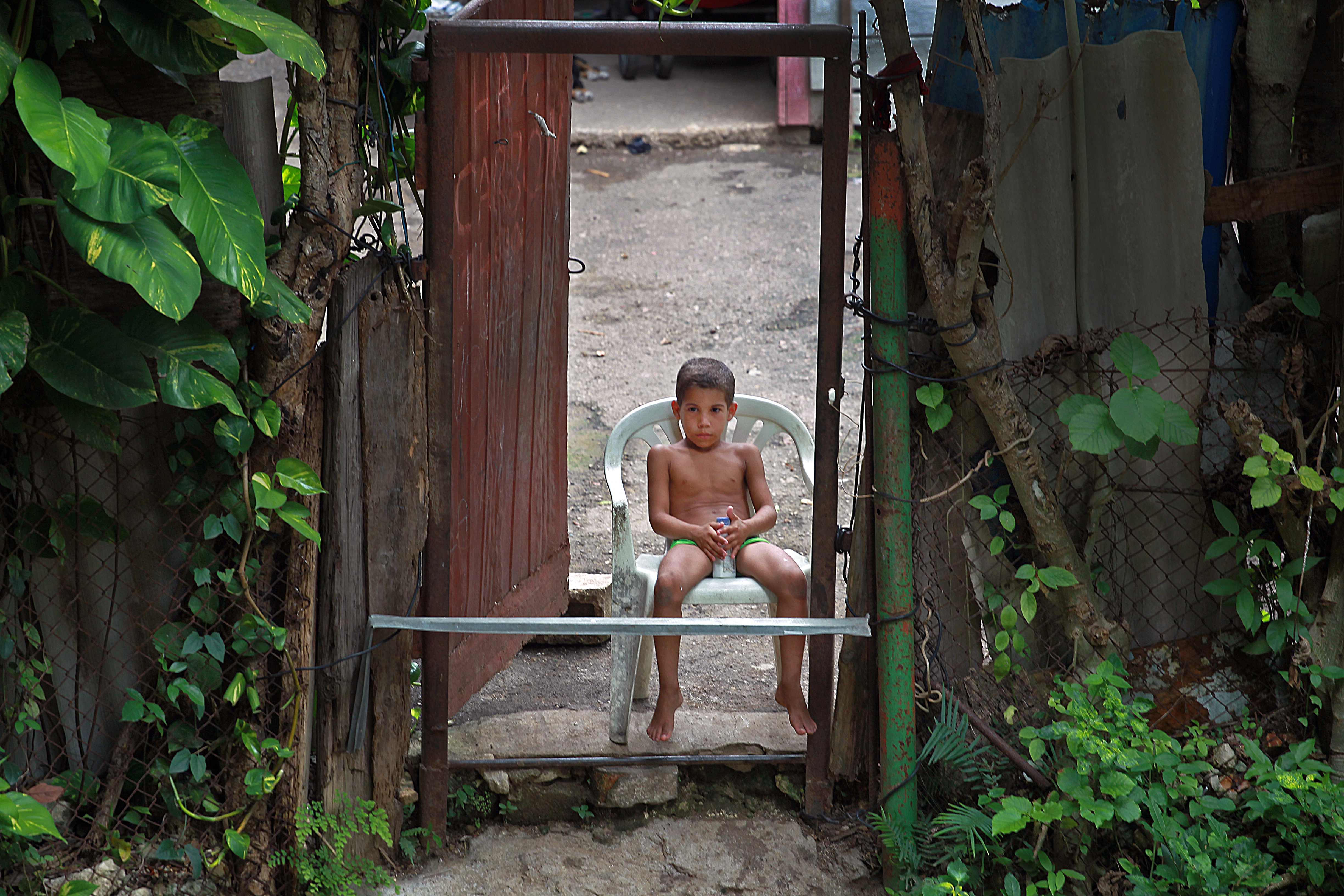 A young boy sits at the door to his home in El Hueco.