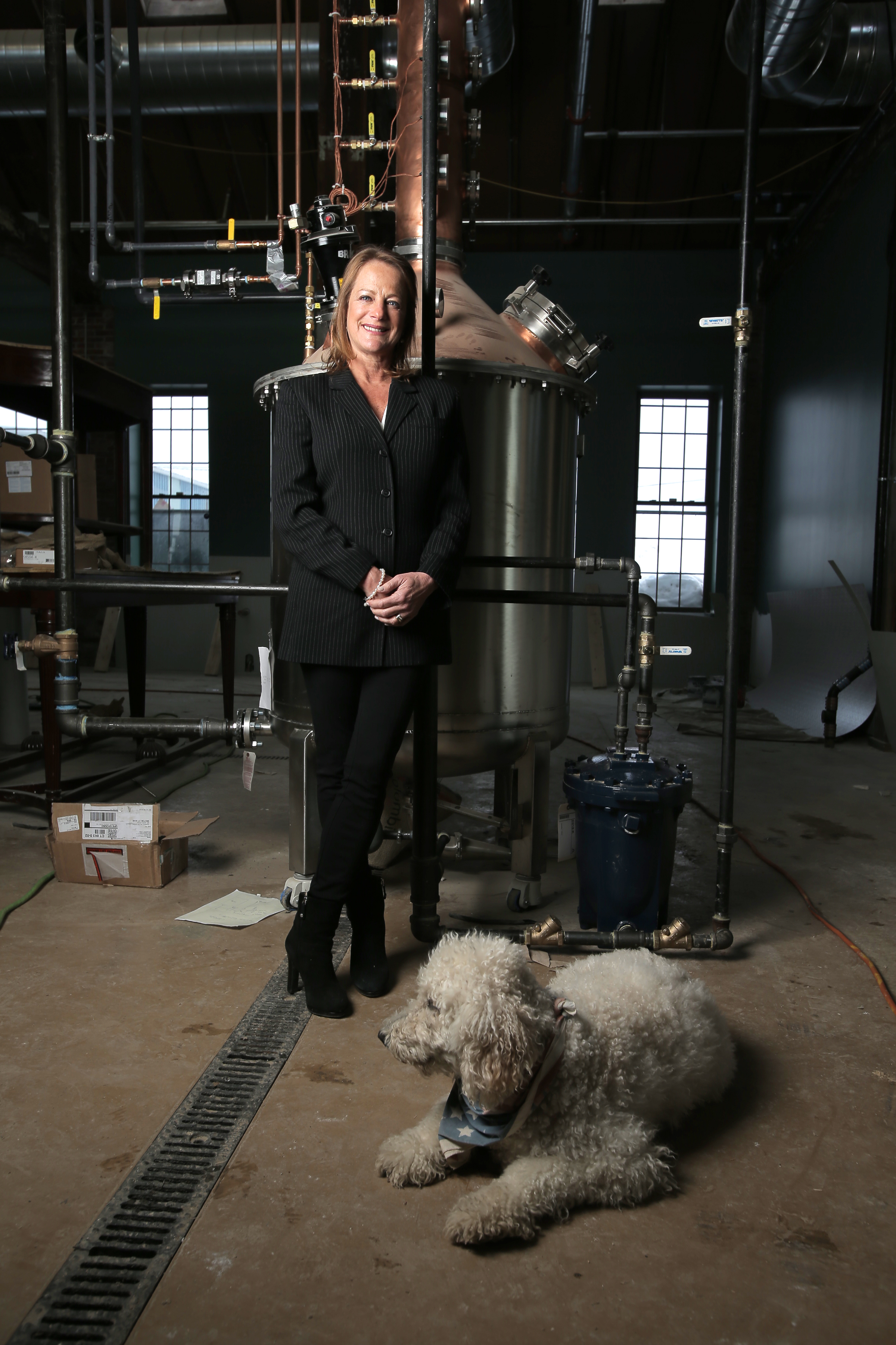 Rhonda Kallman and her dog Sandy, at the Boston Harbor Distillery, which is under construction in a Civil War-era complex in Dorchester.
