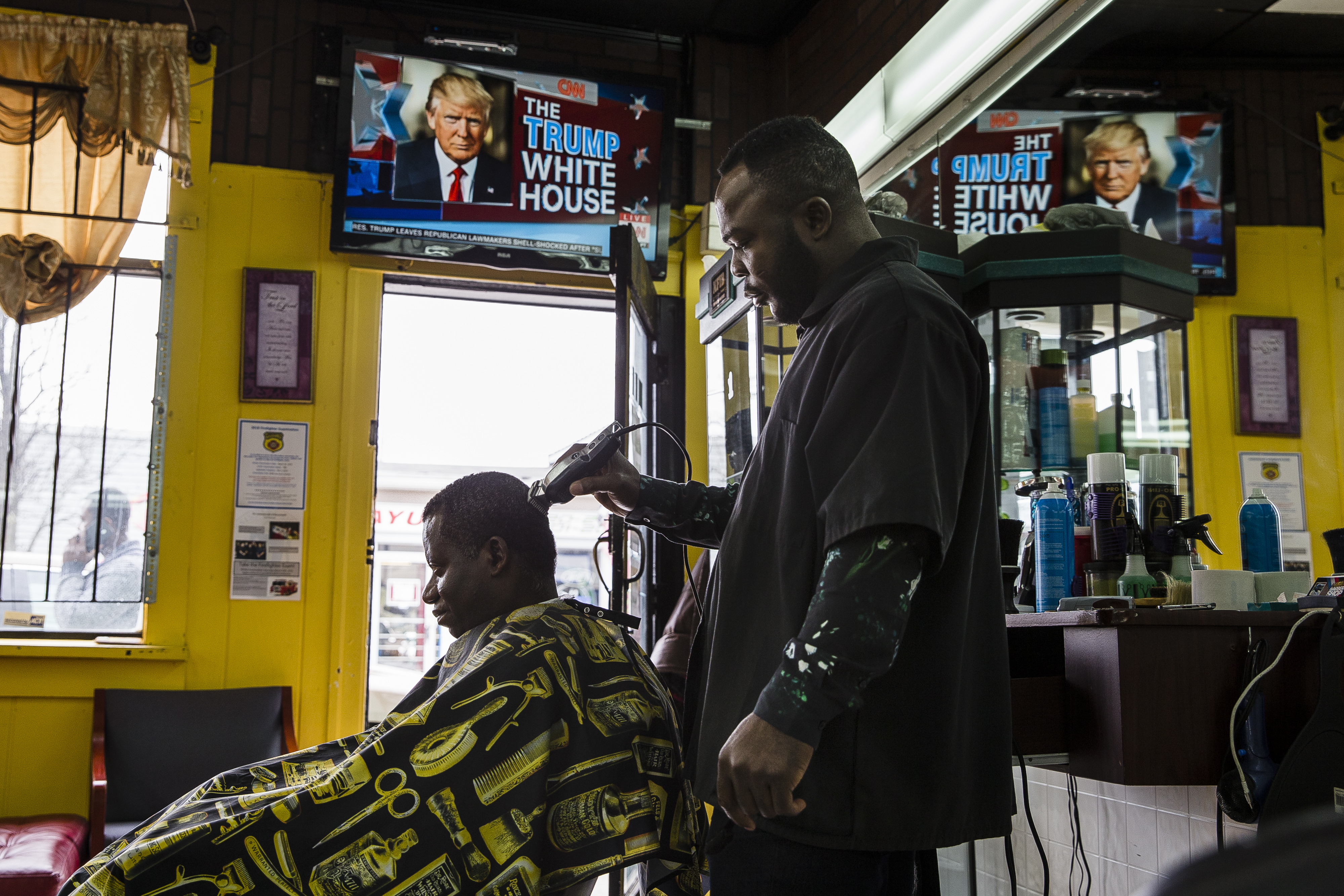 A Ghanaian barber cut a customer’s hair at a shop in Worcester. The city is home to one of the largest Ghanaian communities in the United States. Many Ghanaian home care workers live there, and many shops and restaurants cater to people from Ghana.