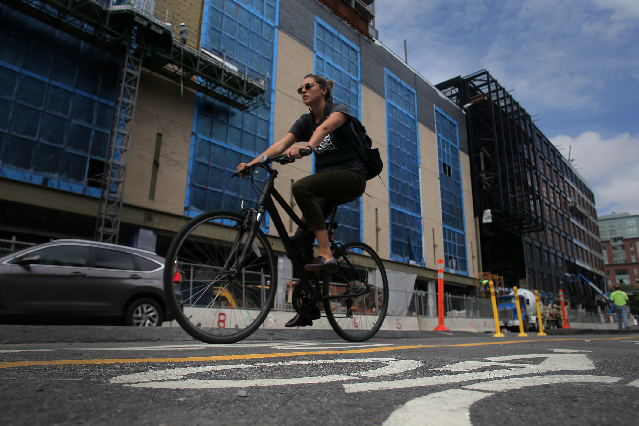 A cyclist on the new protected bike lane on Causeway Street passed new construction.