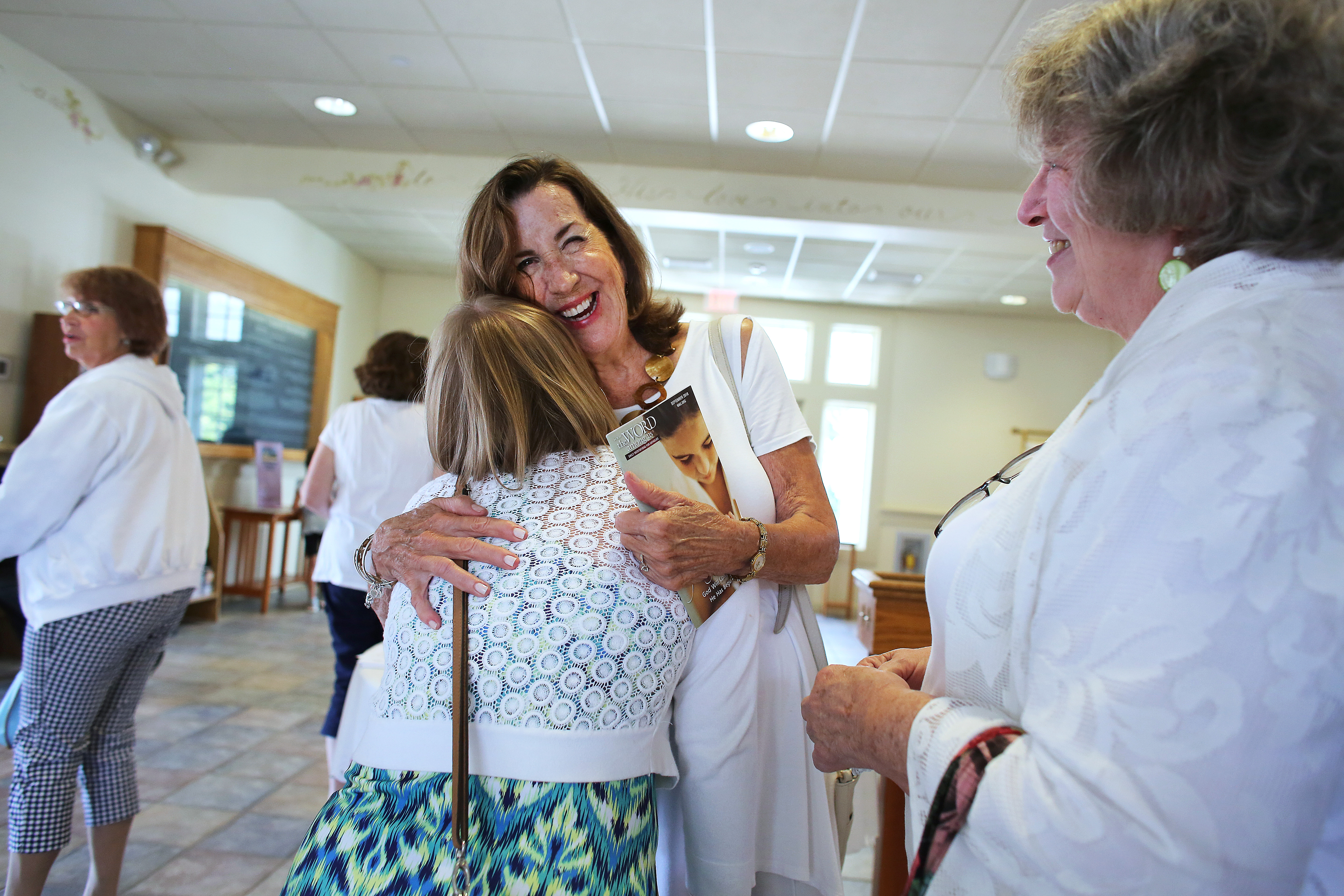 Lector Marilyn Shaw (facing center) embraced Rachel Tamulevich after Mass.