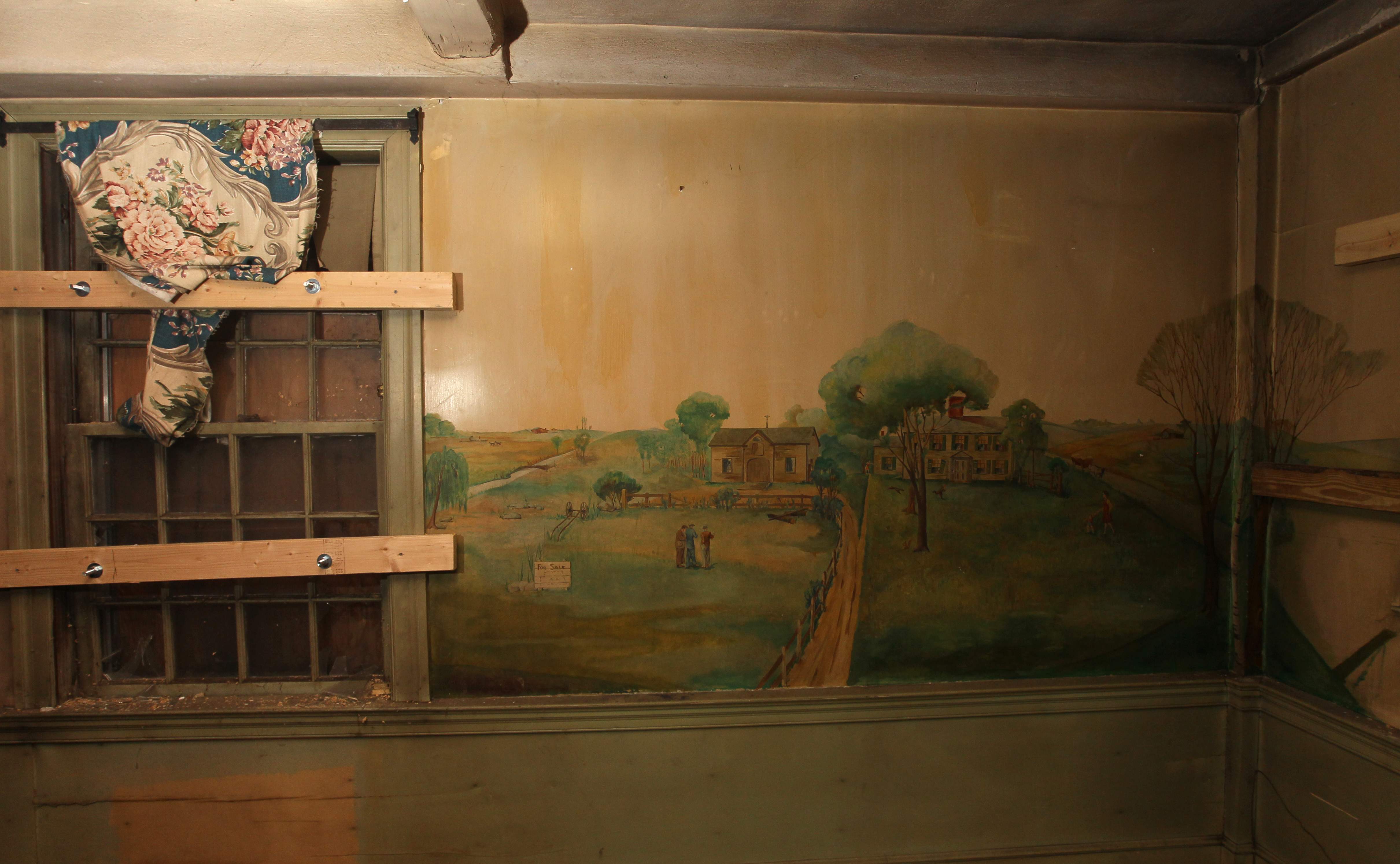 A mural of lush green hills and the farm itself can be seen in one of the home’s original rooms.