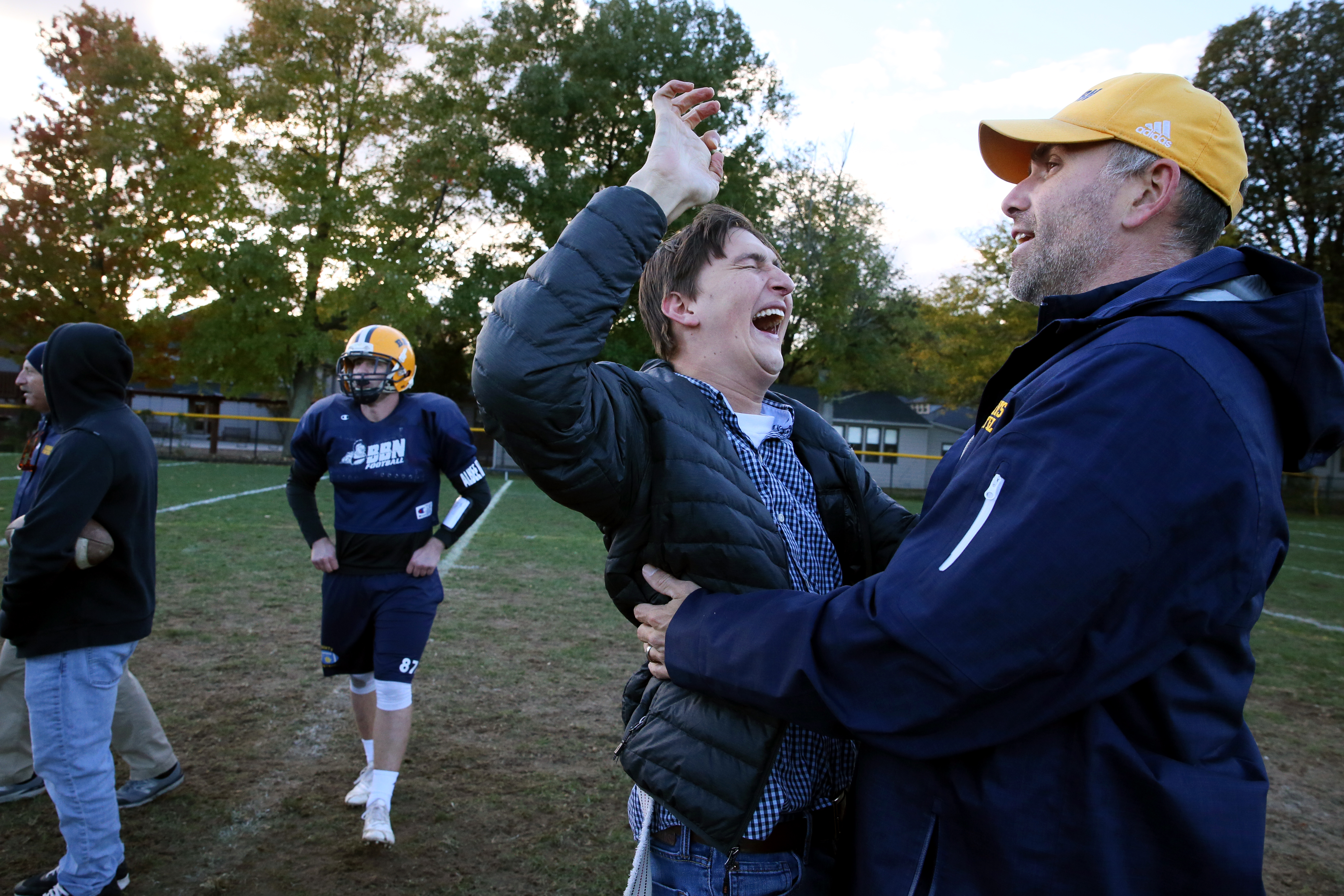 Former BB&N football player Zach McLeod is greeted by coach Mike Willey during practice at the school.