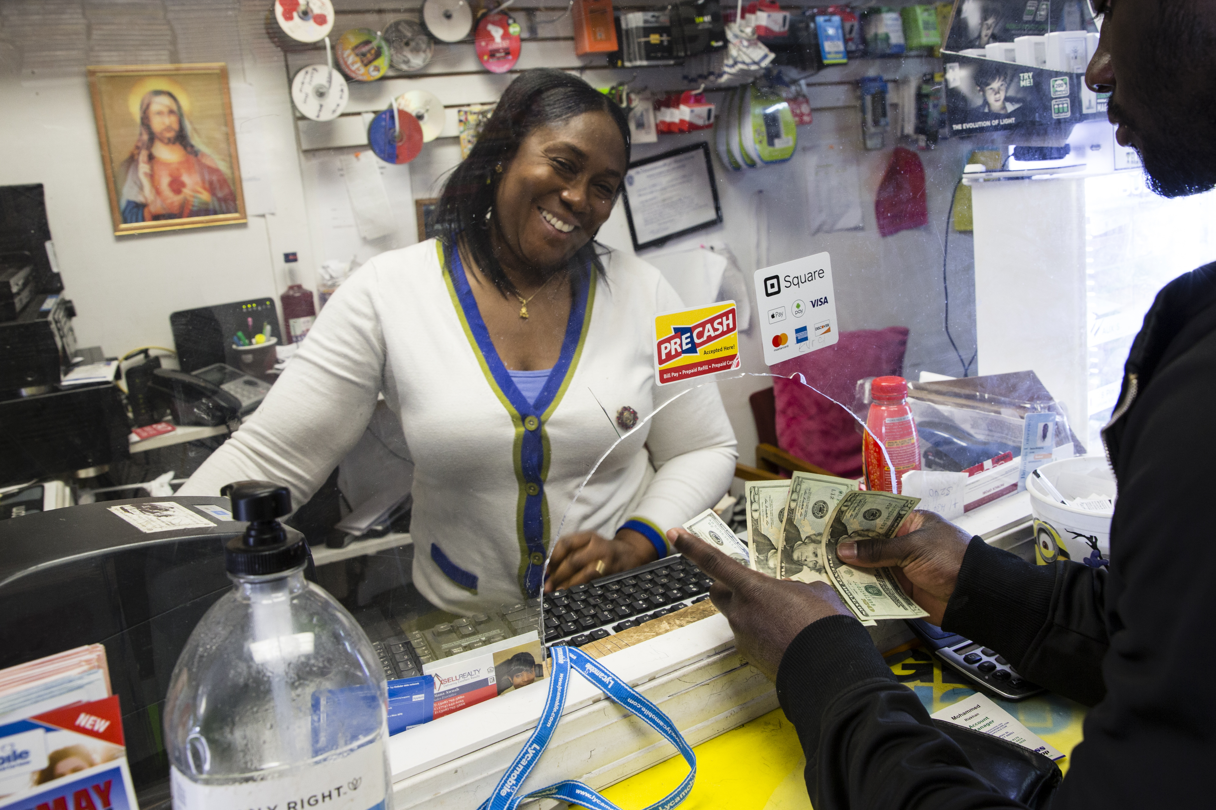 Gloria Camara took cash from a customer sending a “remittance” home to Ghana. Her shop is on Main Street in Worcester.