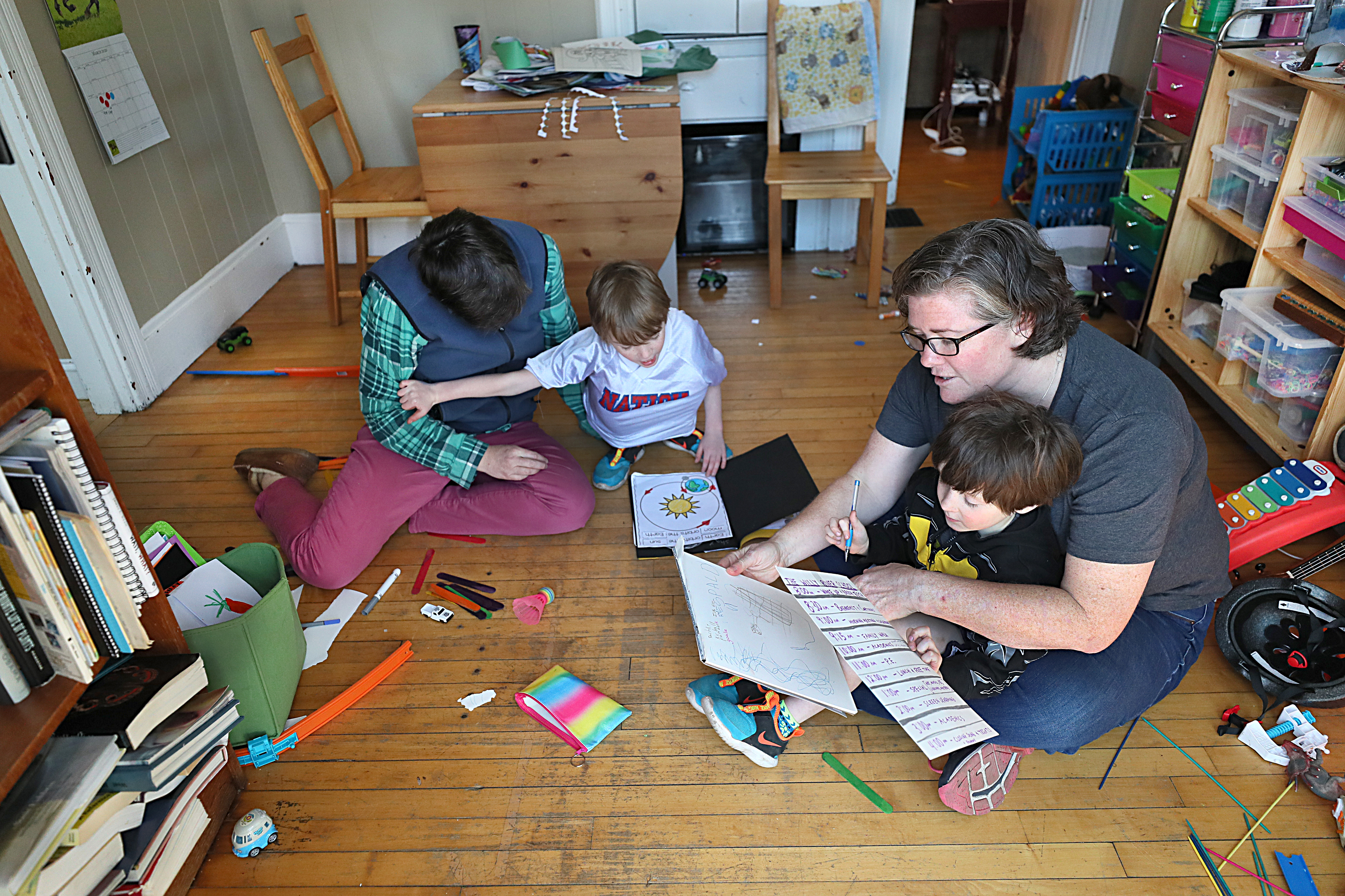 Jennifer Green, left, and Lisa Spalding, right, tred some activities with their sons, Shay. left, and Rye, as they work from home because of the coronavirus pandemic.