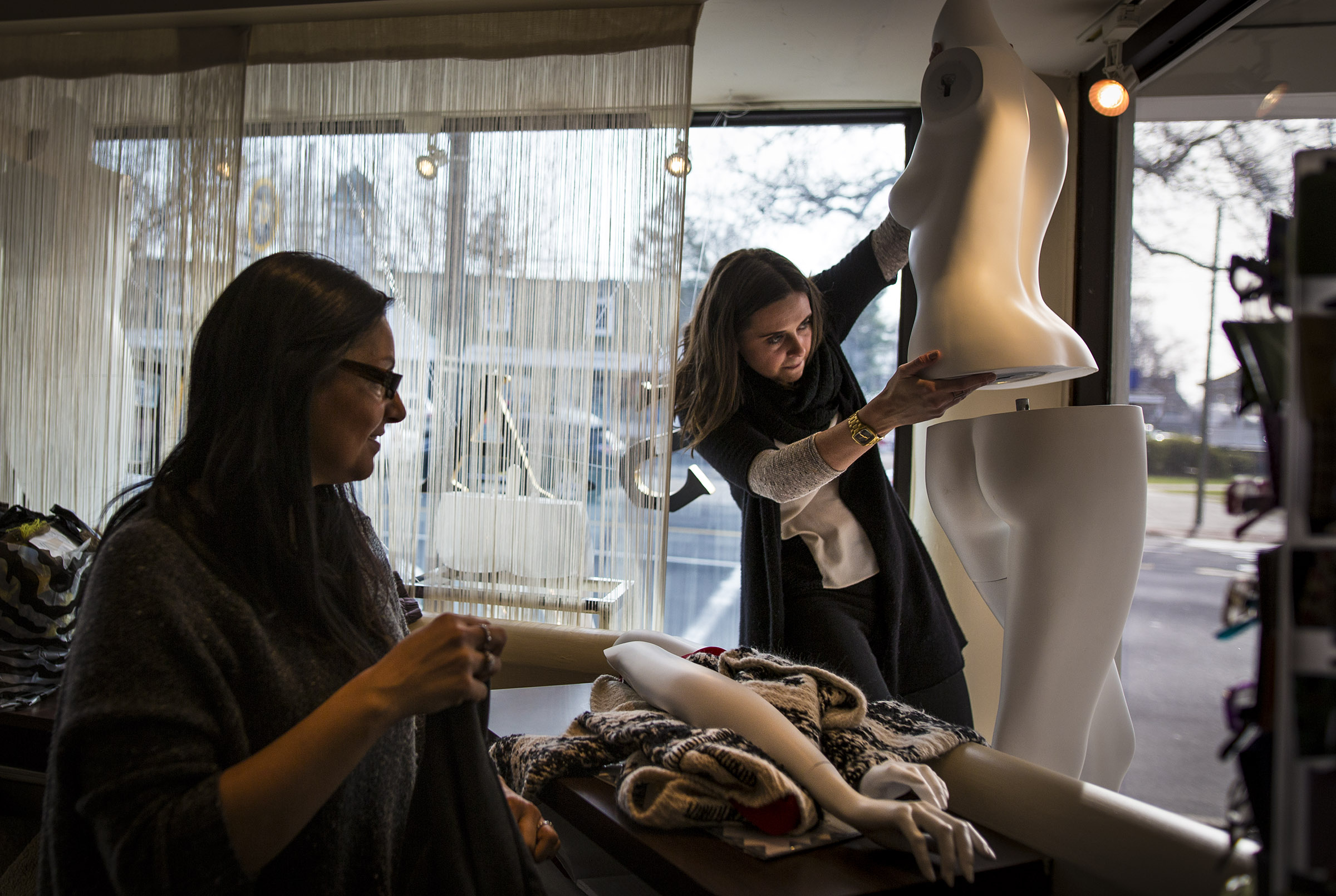 Jori Tallman (left) and Ryan Sullivan worked on a window display at women’s boutique store La Moda Fashions.