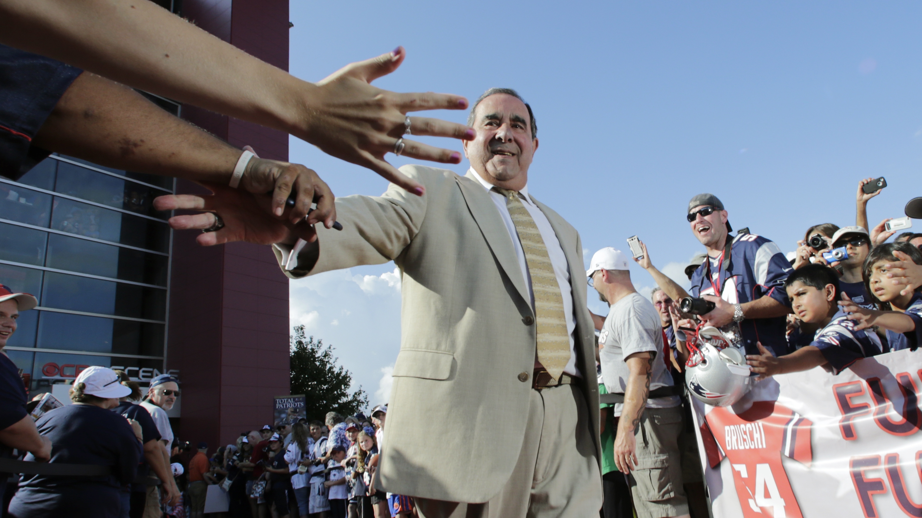 Former New England Patriots broadcaster Gil Santos was congratulated by fans as he walked the red carpet in Foxborough, Mass.
