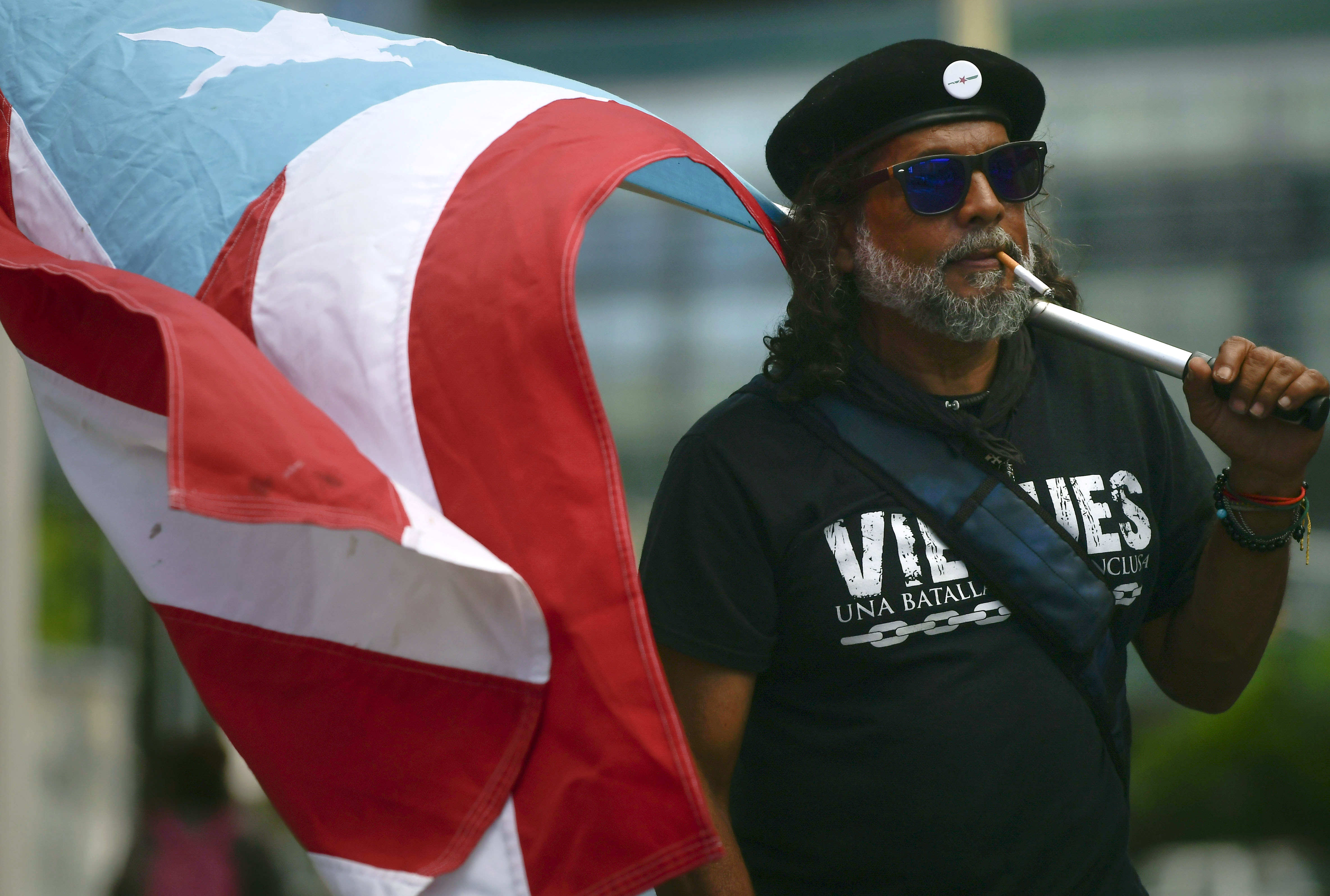 A protester carried a Puerto Rican flag during a protest against the Federal Fiscal Control Board, as part of the May Day celebration, in San Juan, Puerto Rico.