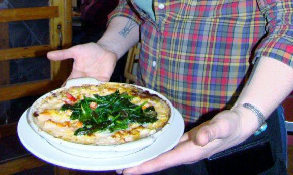 CAFE MIRANDA - The baked lobster mac ’n cheese is studded with tomatoes and topped with greens.