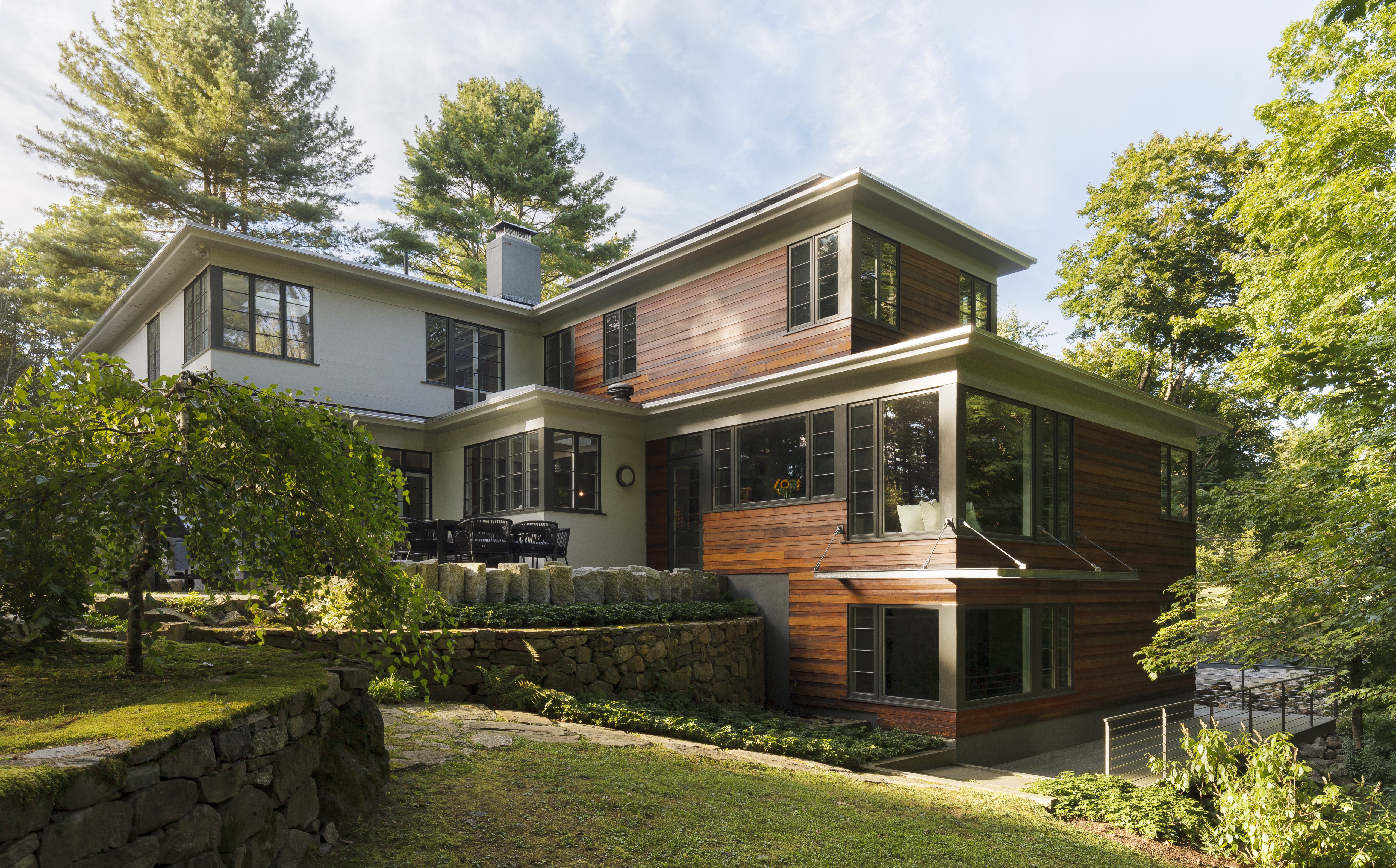 Wolf’s wood-clad addition stands in pleasing contrast to the white painted exterior of the original house. Lincoln-based landscape architect Jonathan Keep redesigned and enlarged the patio outside the dining room.