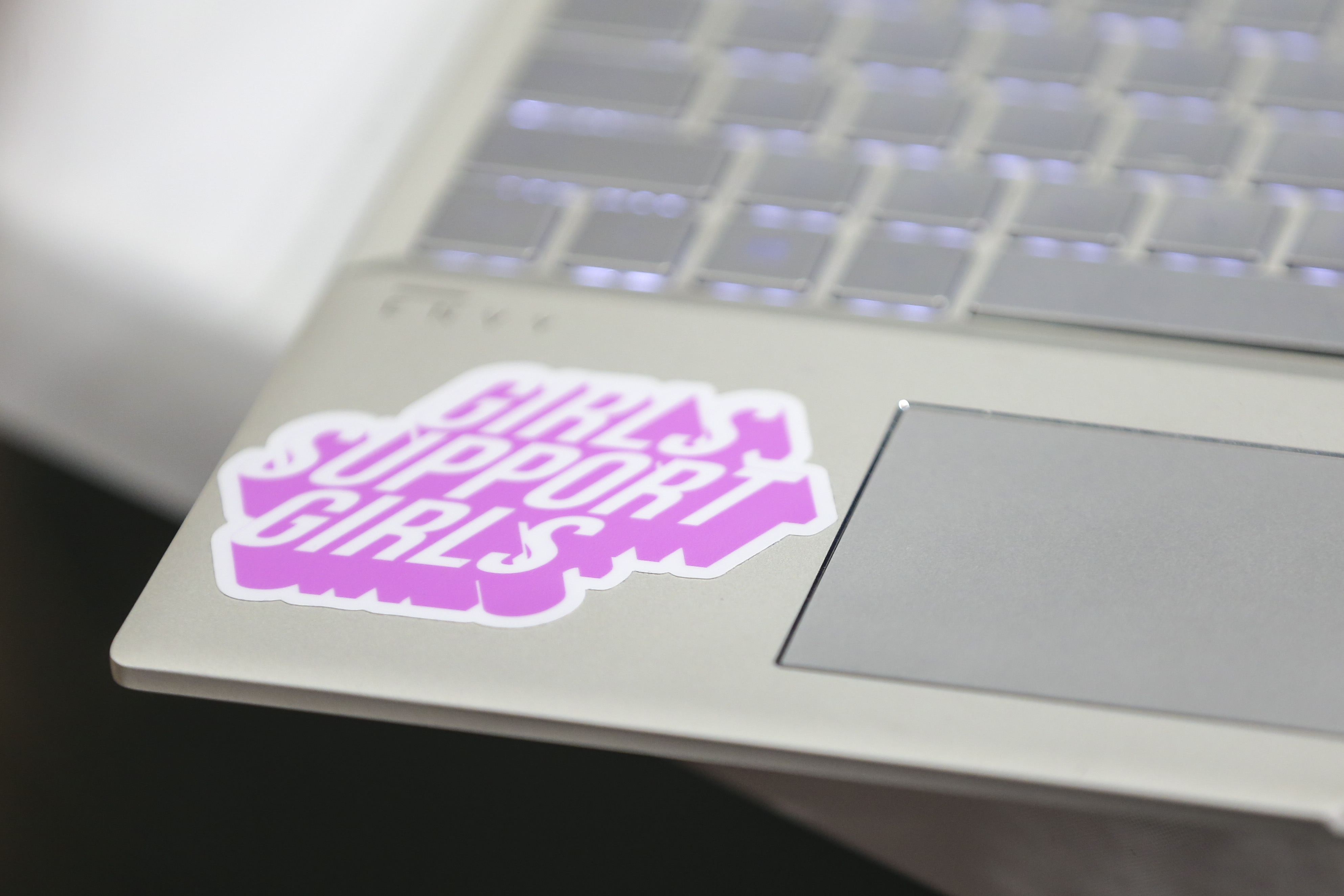 A sticker reading "Girls Support Girls" on the laptop of a TechTogether hackathon participant.