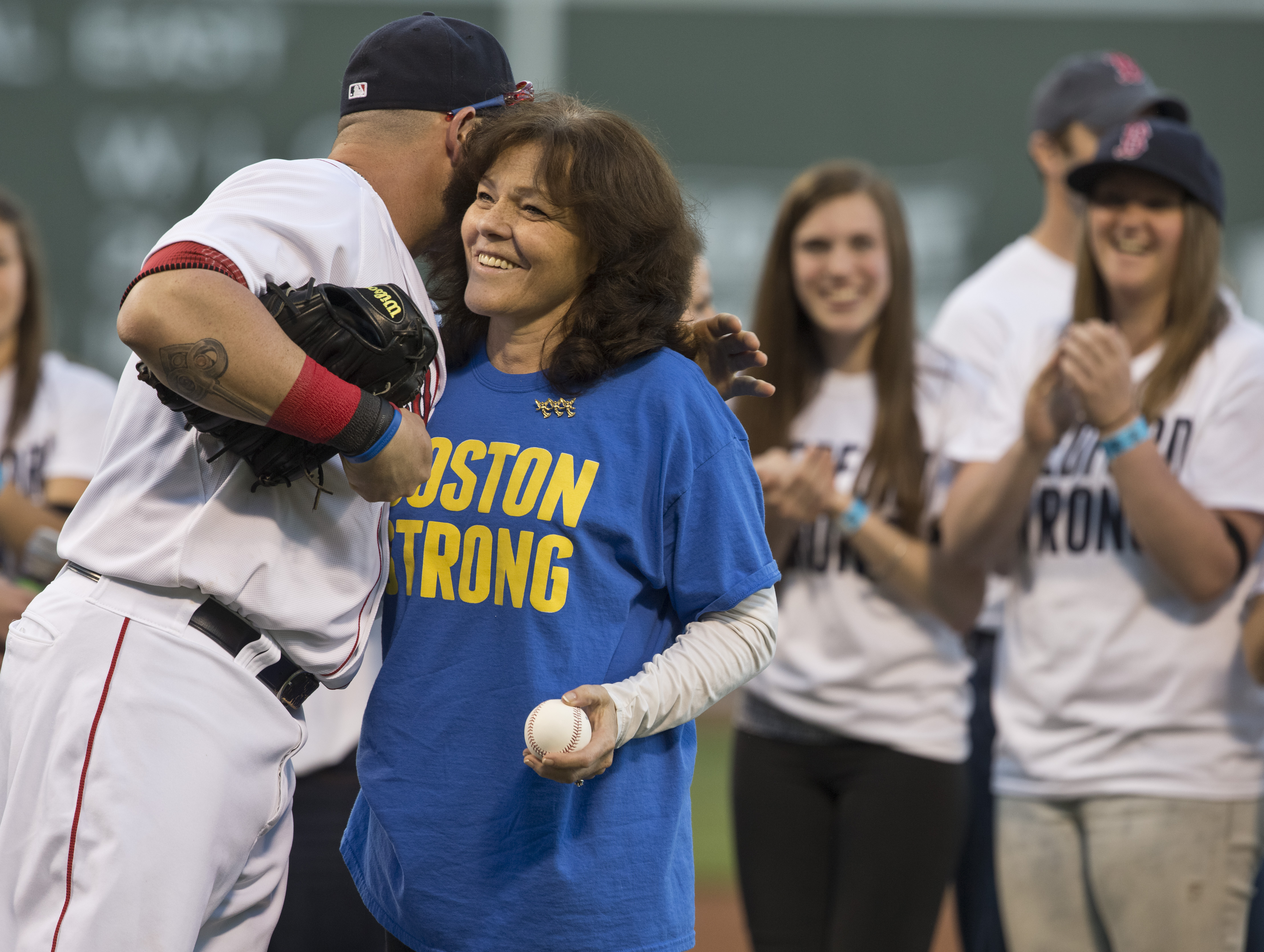 Patricia A. Campbell got a hug from Jonny Gomes of the Red Sox after she threw out the first pitch before a game against the Minnesota Twins at Fenway Park on Tuesday, May 7 2013.
