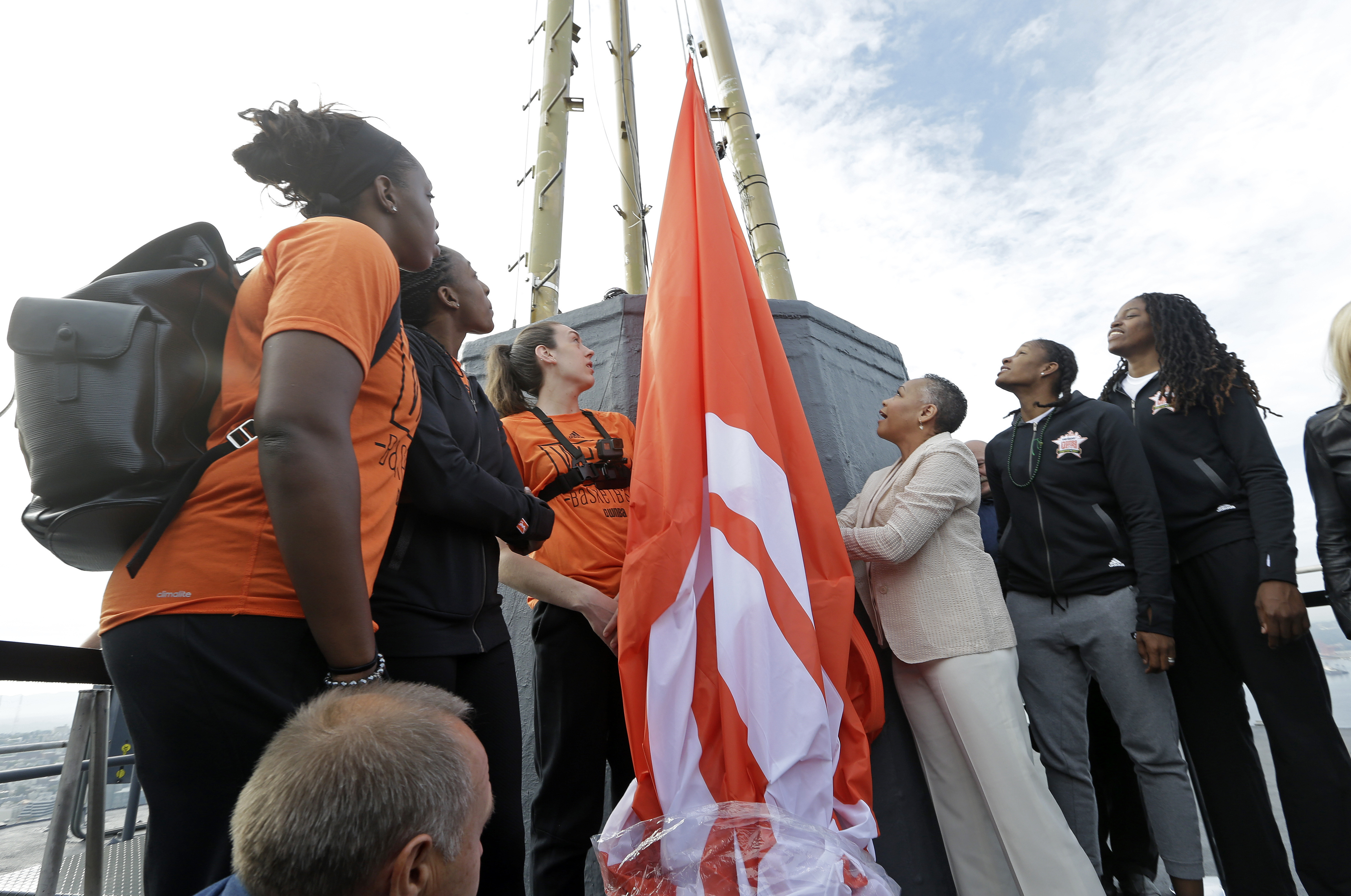 Lisa Borders raises the WNBA flag atop the Seattle Space Needle, along with players Chelsea Gray, Nneka Ogwumike, Breanna Stewart, Rebekkah Brunson, and Jonquel Jones.