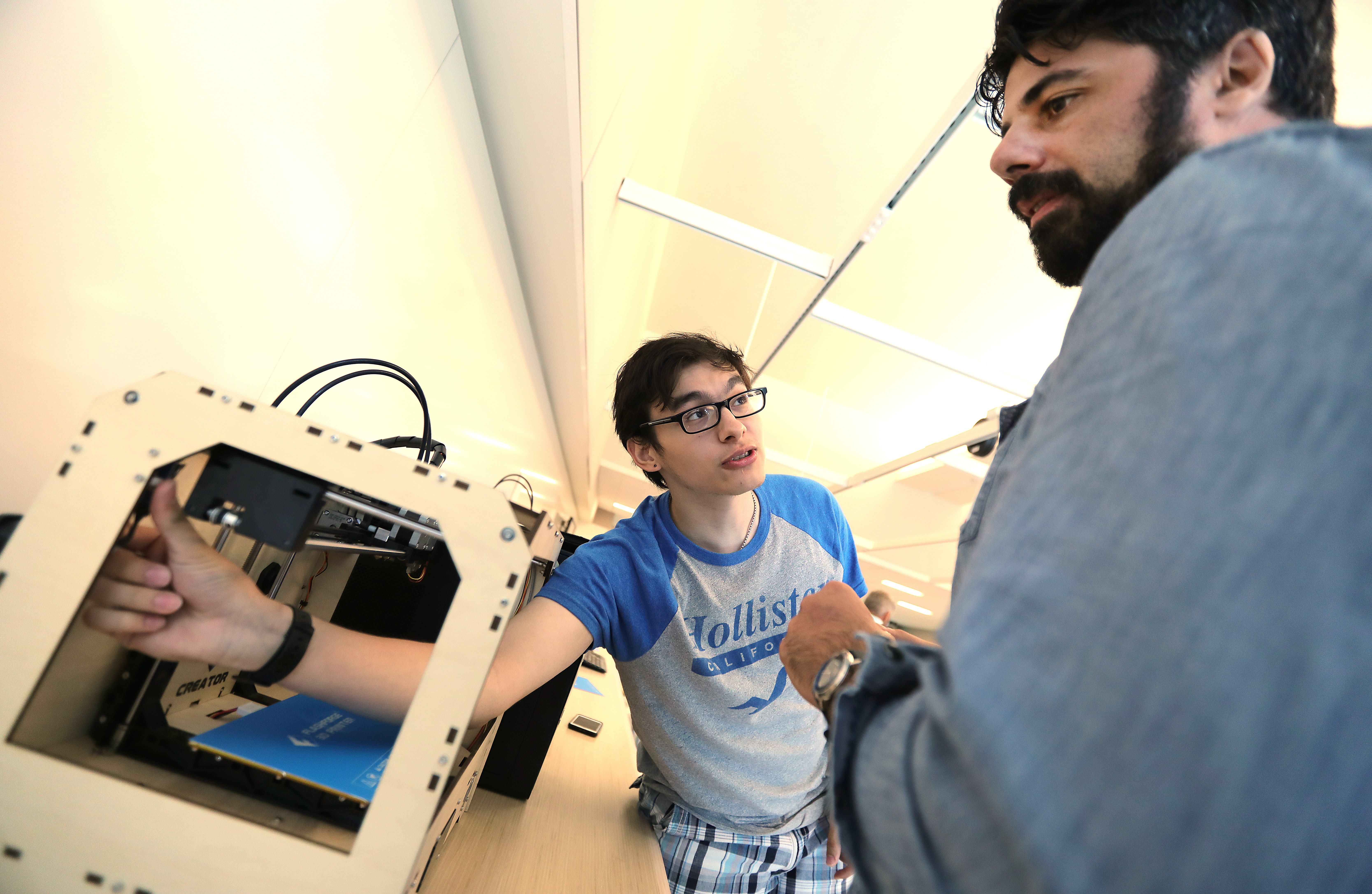 In the digital lab, senior Elias Arroyave, 18, told computer science teacher Jon LoPorto what he figured out about the 3D printer.