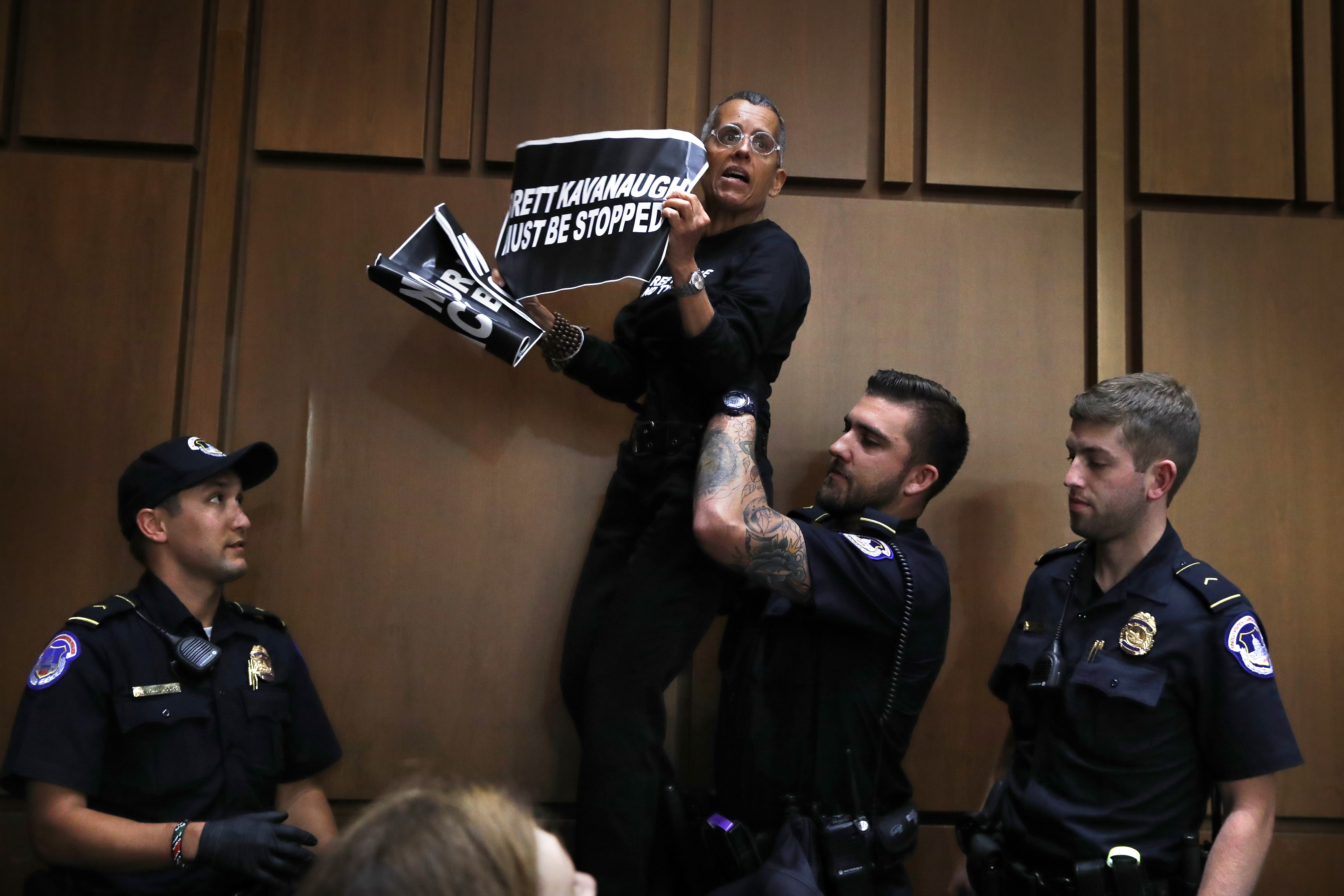 A protester was lifted off of a chair by U.S. Capitol Police while standing on it and shouting during testimony by President Donald Trump's Supreme Court nominee Brett Kavanaugh in Washington.