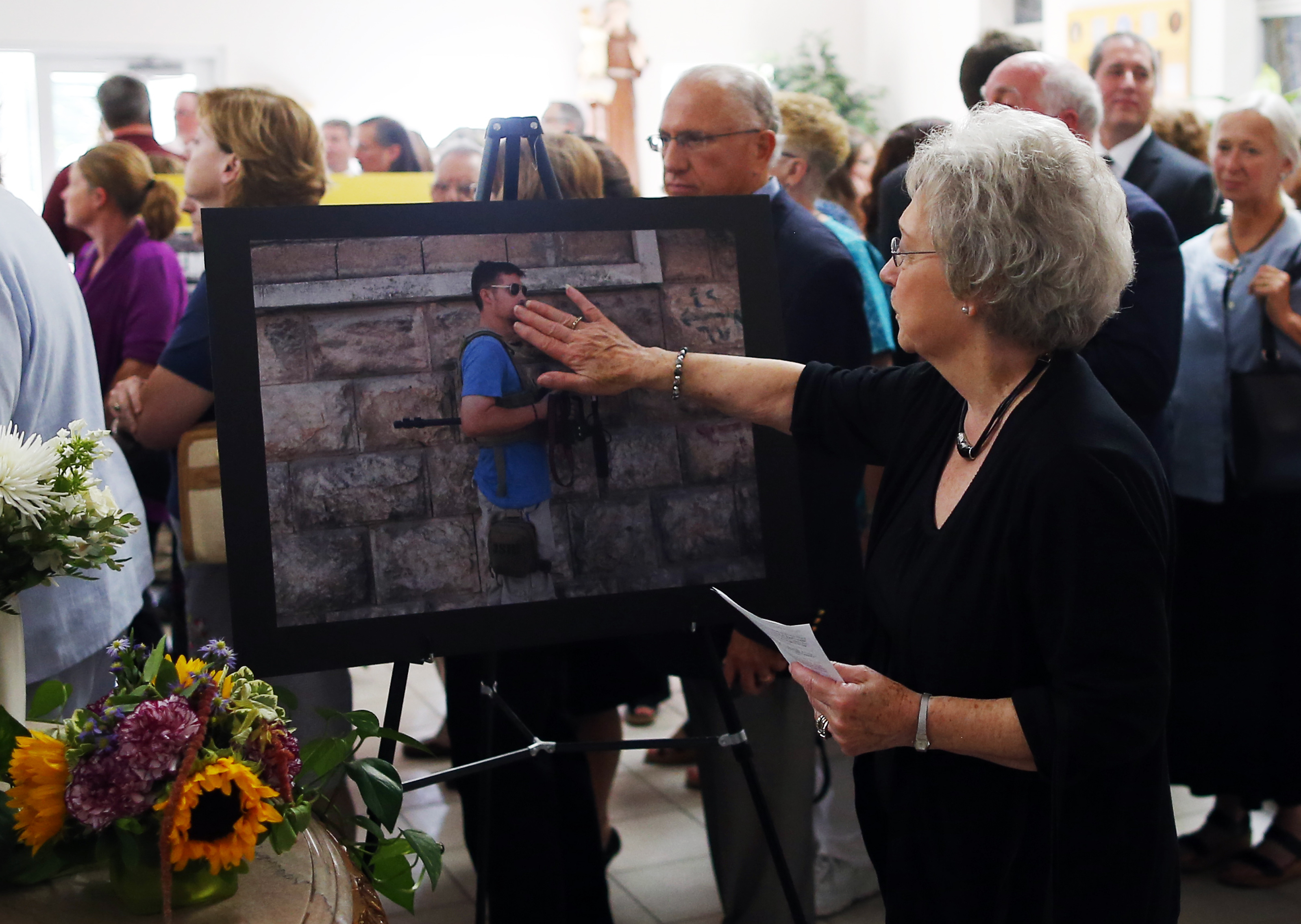 Wolfeboro town clerk Pat Waterman, whose son was a good friend of James Foley’s, placed her hand to a picture of the slain journalist.