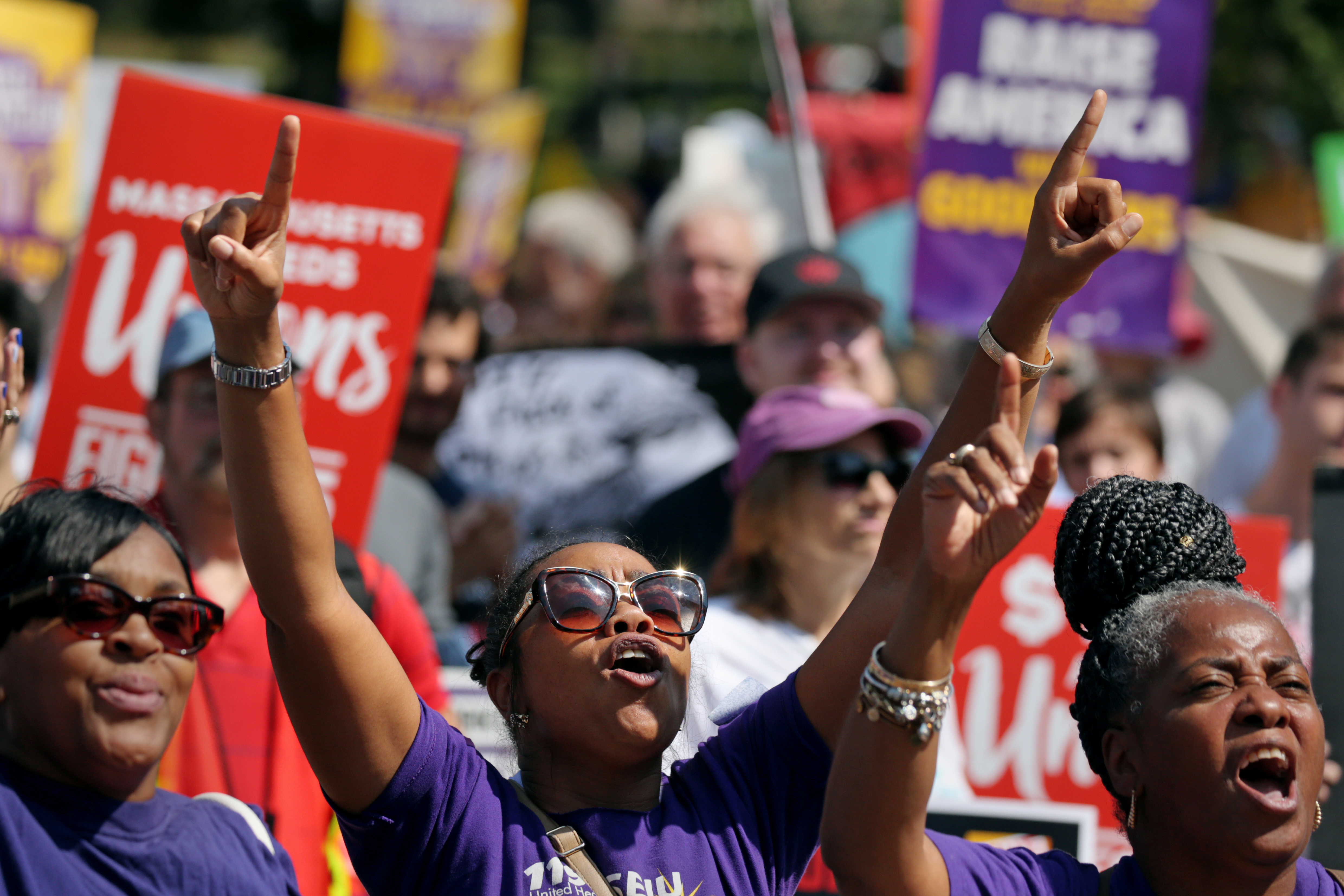 Teia Searcy, center, joined in a chant during a Labor Day rally at Boston Common.
