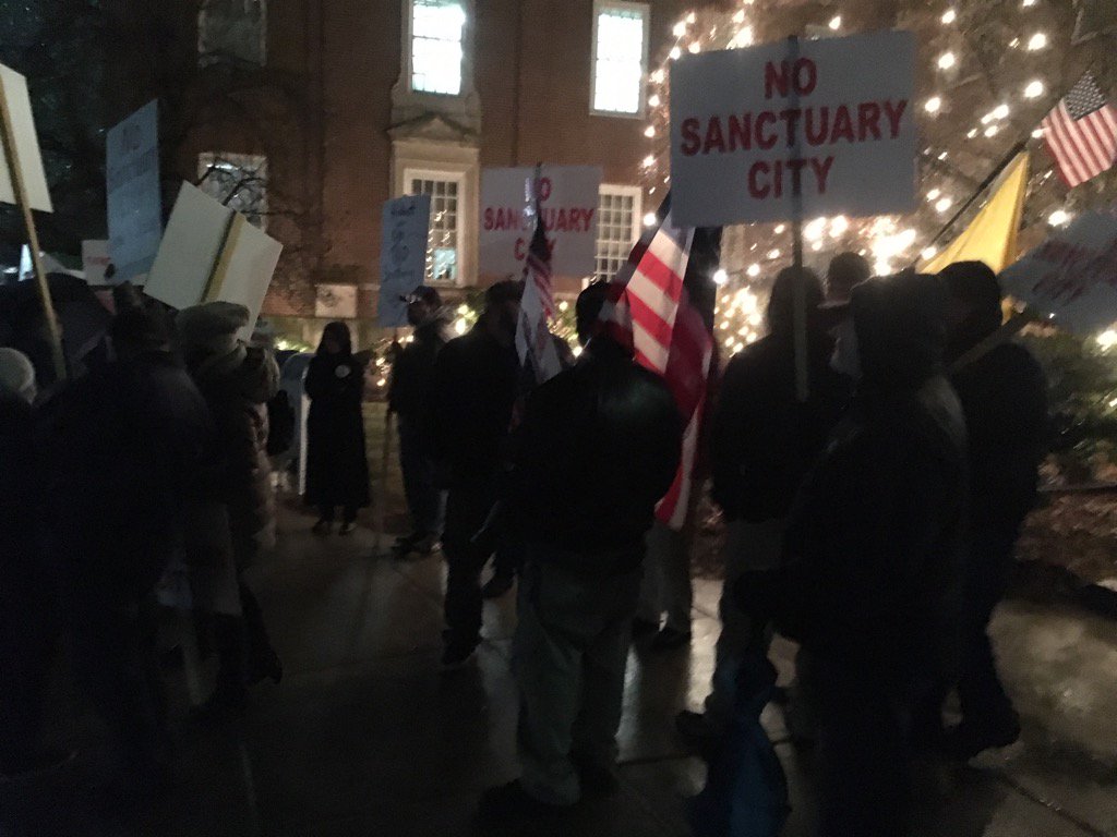Protesters carried signs Wednesday outside Newton City Hall.