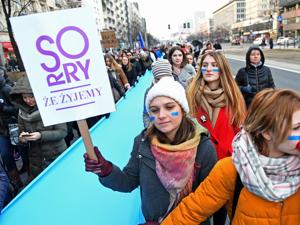 A woman held a banner reading 'sorry that we live' during a rally held on International Women's Day in Warsaw.