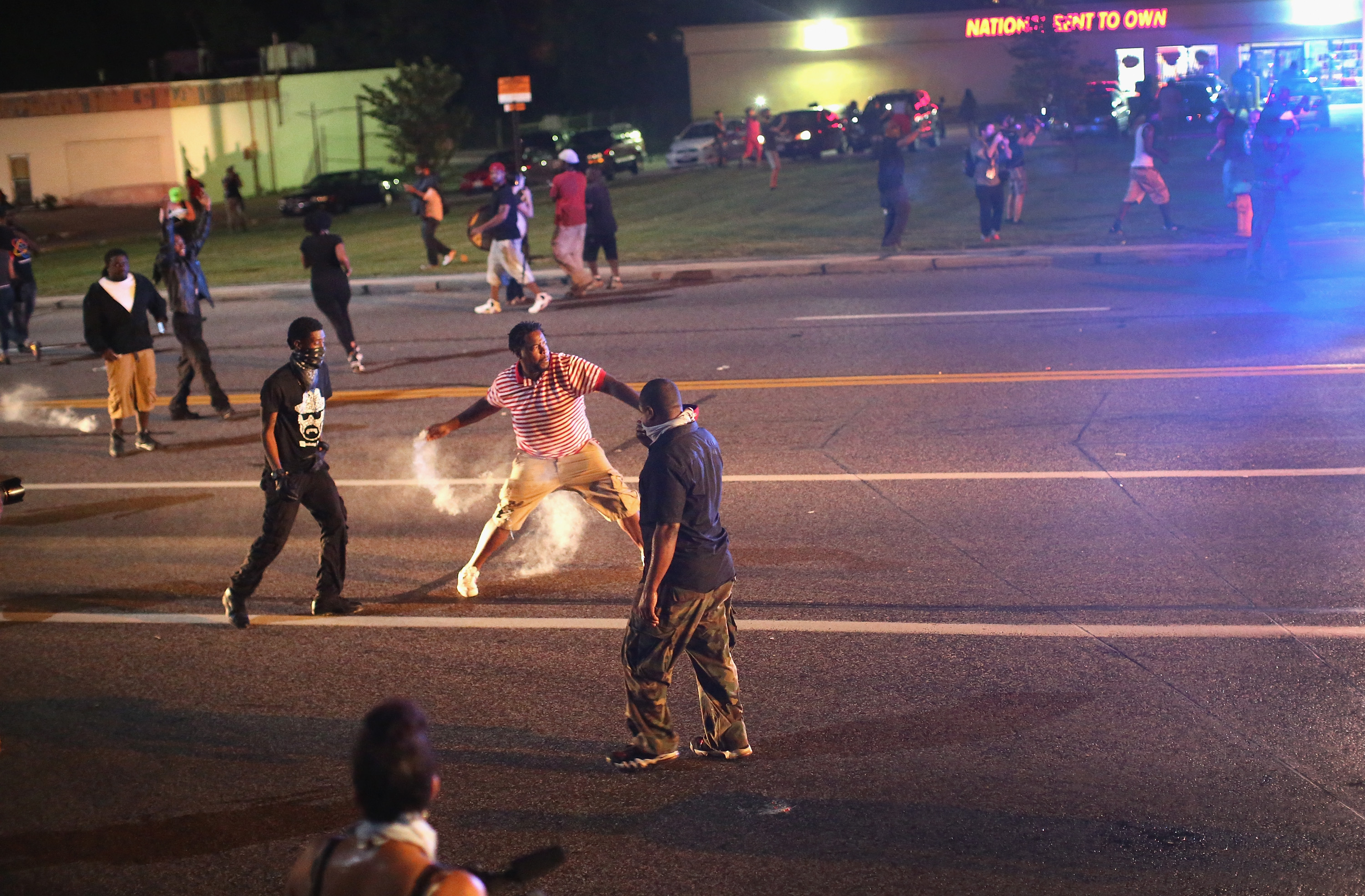 A demonstrator threw a tear gas grenade back toward police.