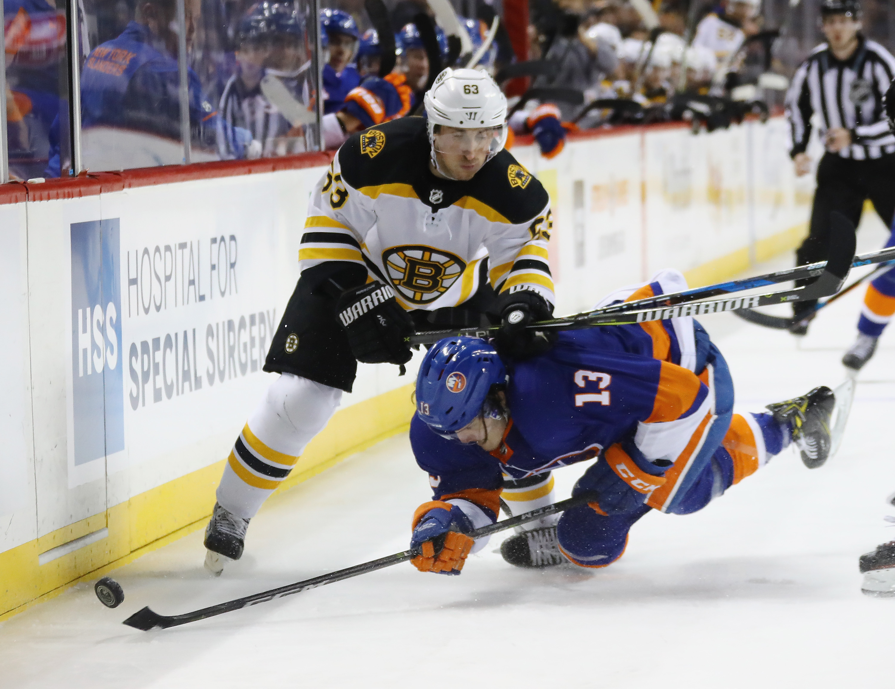 Brad Marchand, who sealed the game with an empty-netter in the third period, knocks the Islanders’ Mathew Barzal to the ice during the second period in New York.