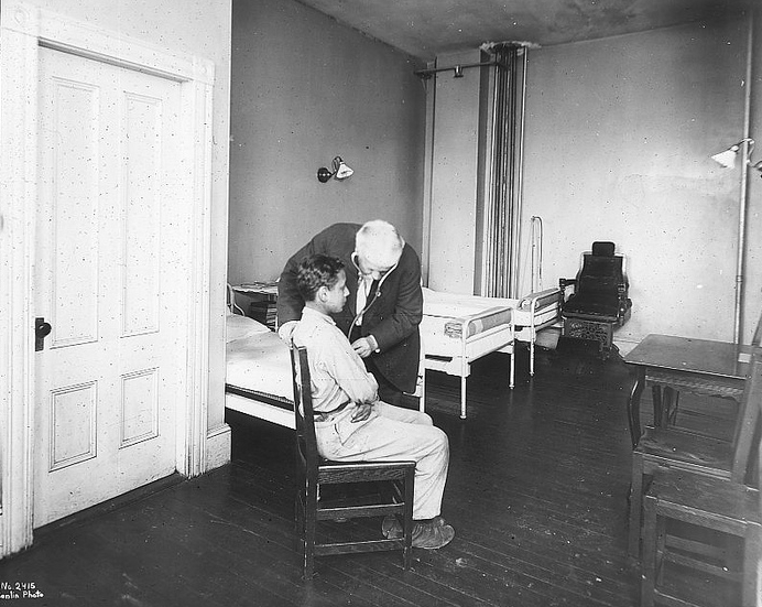 A boy being examined by a doctor on Rainsford Island, circa 1910-20.