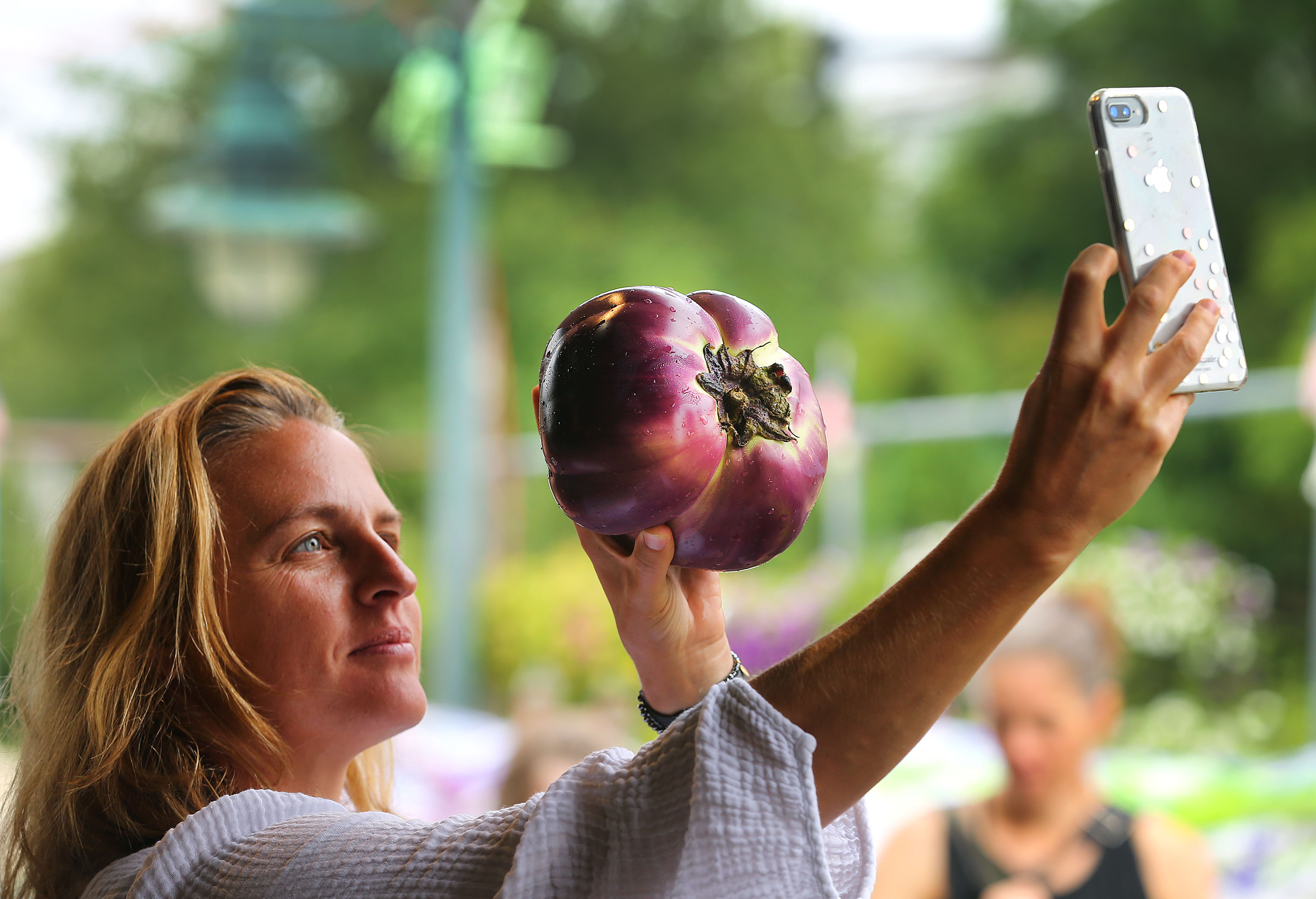 Karen Russo helps her father with marketing; she’ll post the size of this Sicilian eggplant.
