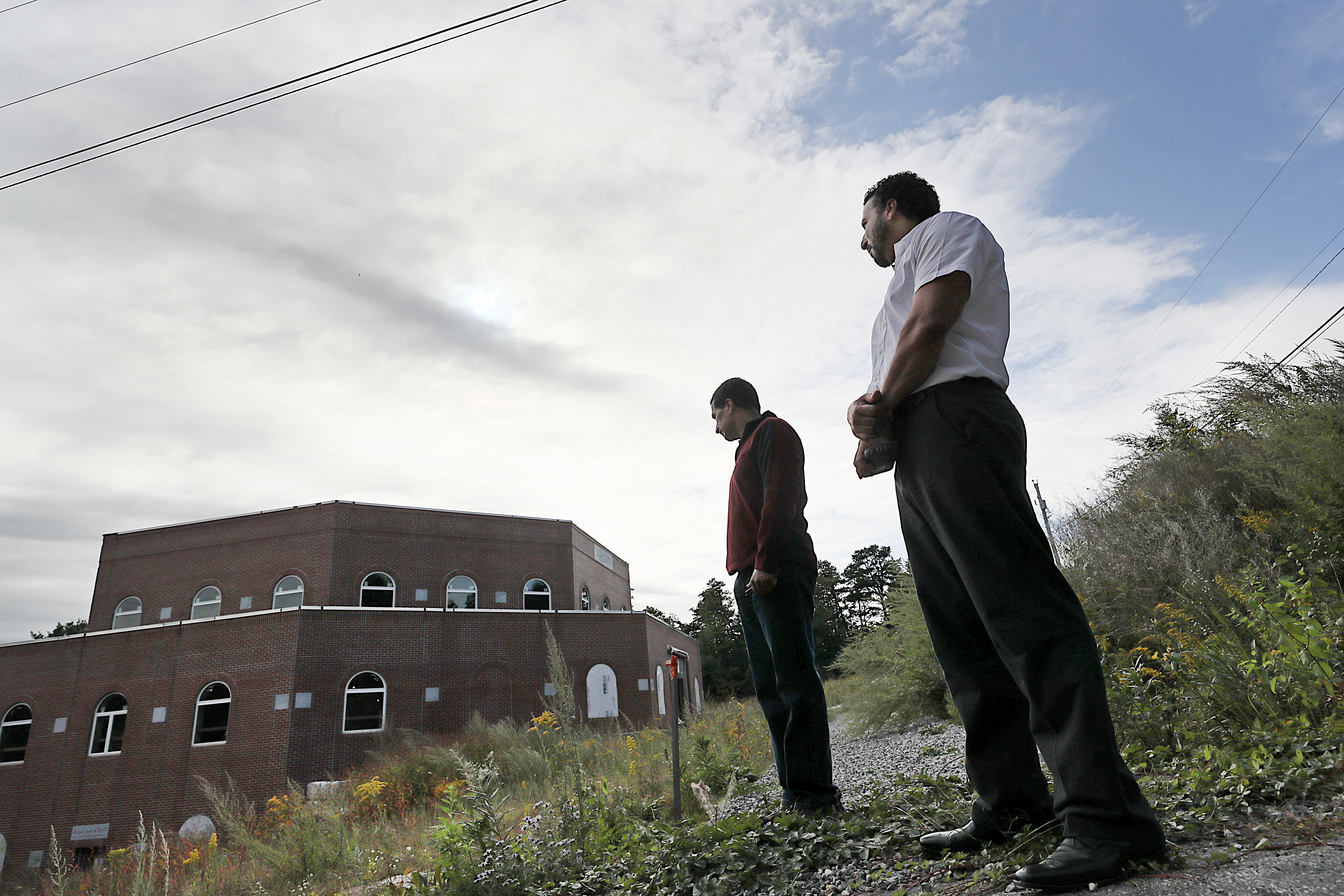 Mohammad Islam, chair of the building committee, and Mohammed Ewiess, mosque board president, surveyed the damage to the unfinished mosque.