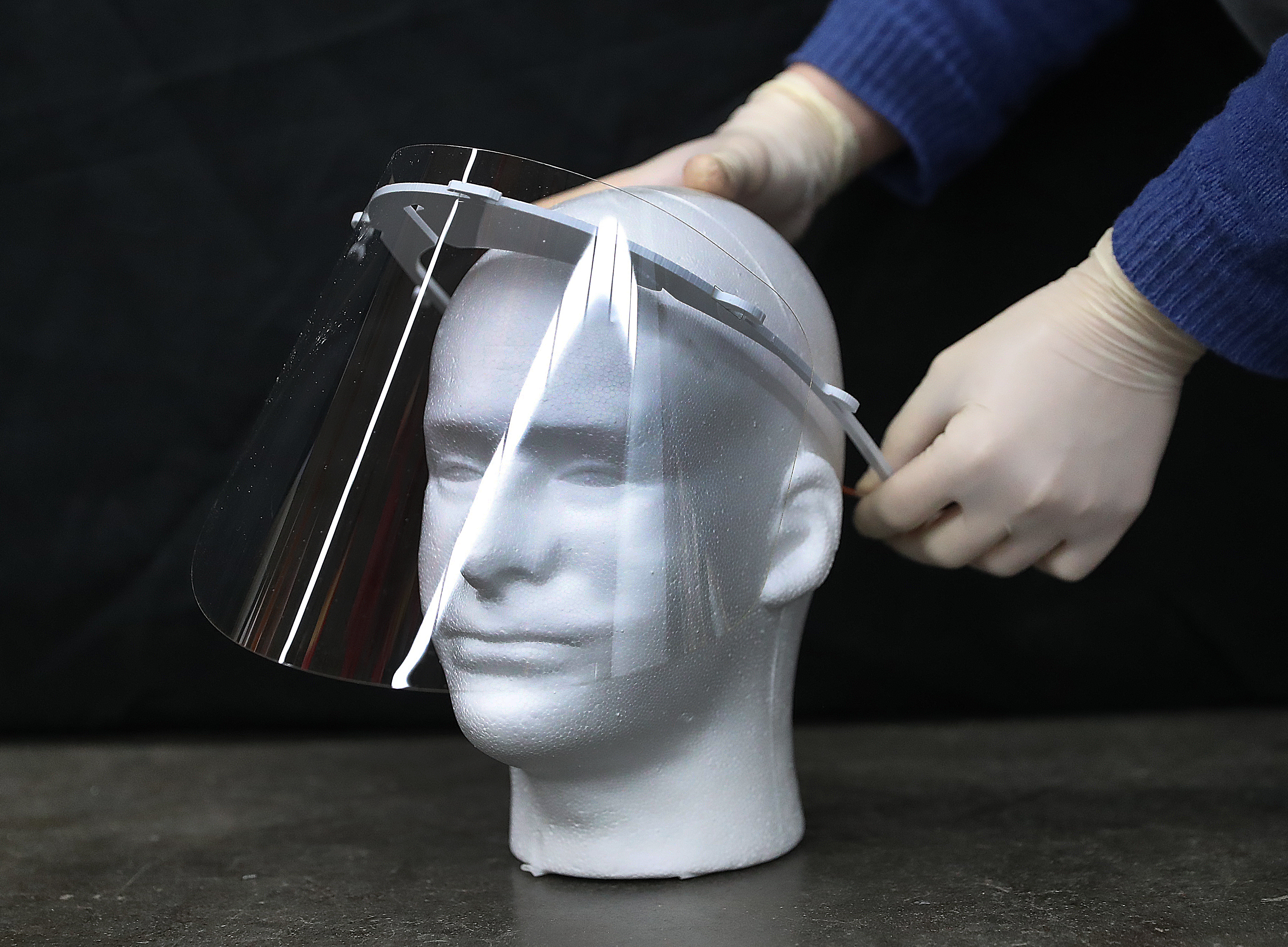 A face shield gets an adjustment at Artisan's Asylum.
