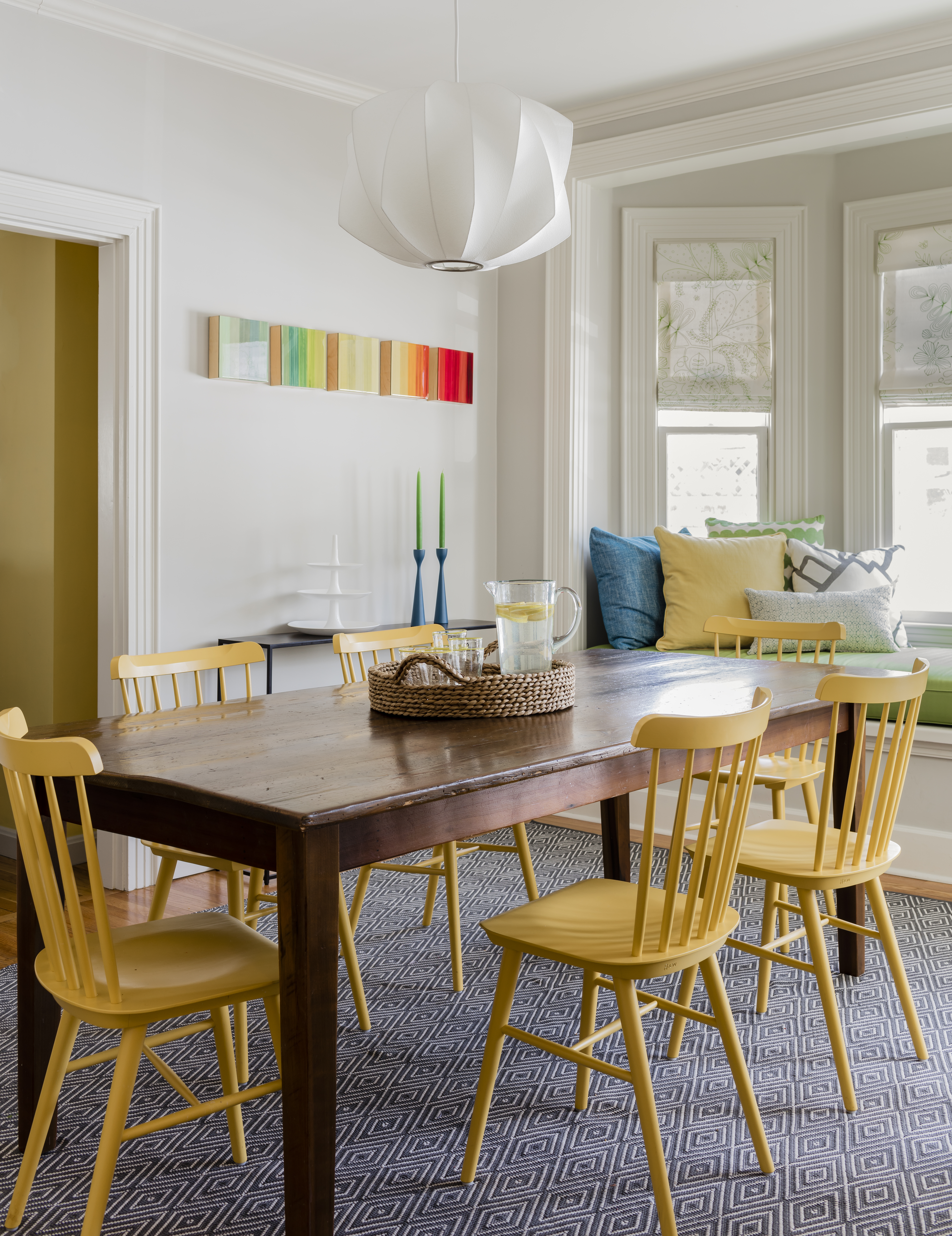 In the dining room, Hirsch dressed the window seat — a.k.a. the “cuddle corner” — with a cushion covered in Sunbrella fabric, Roman shades in an organic leaf design, and throw pillows in colors pulled from the living room.