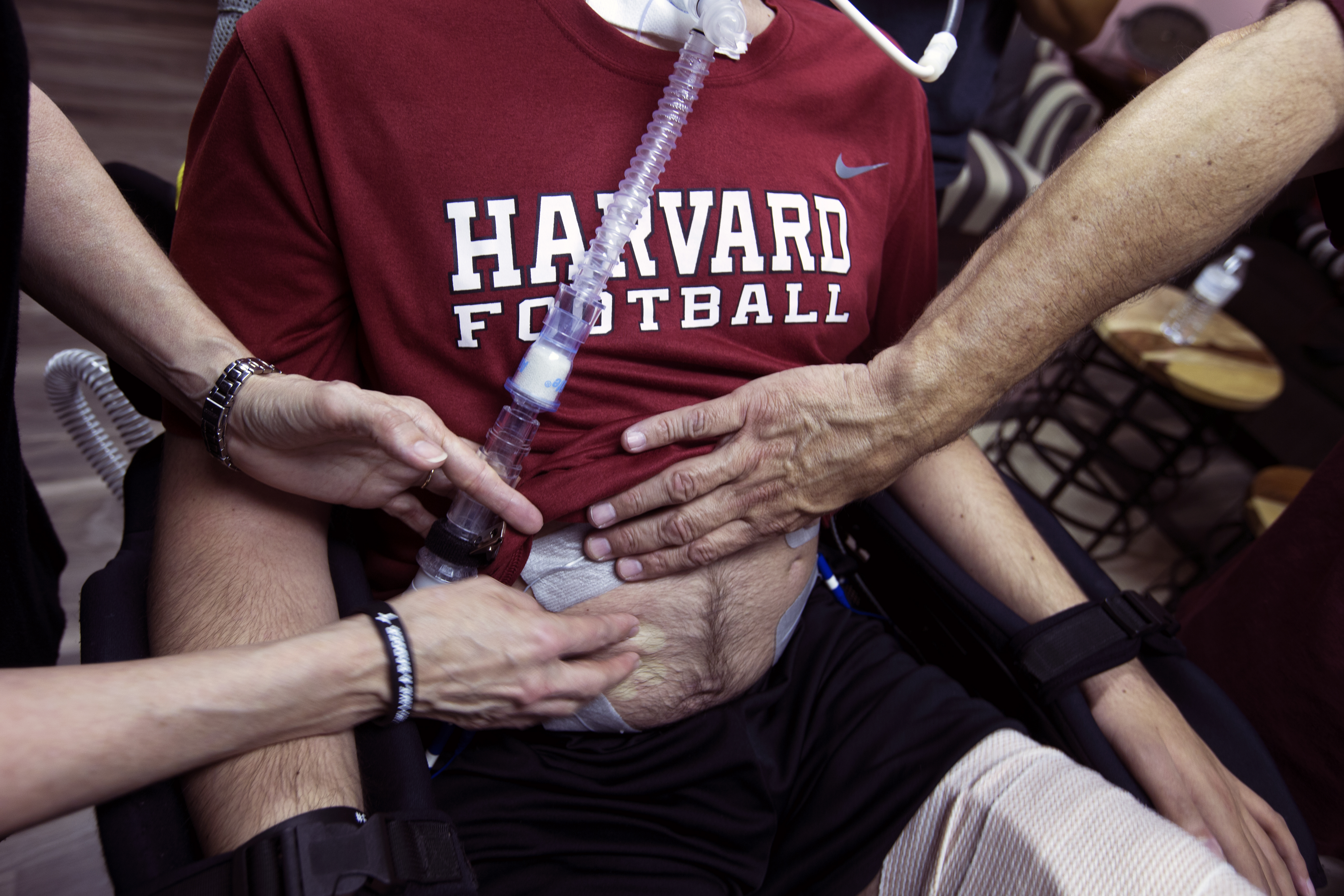 Ben’s family attach electrodes to his body during rehab.