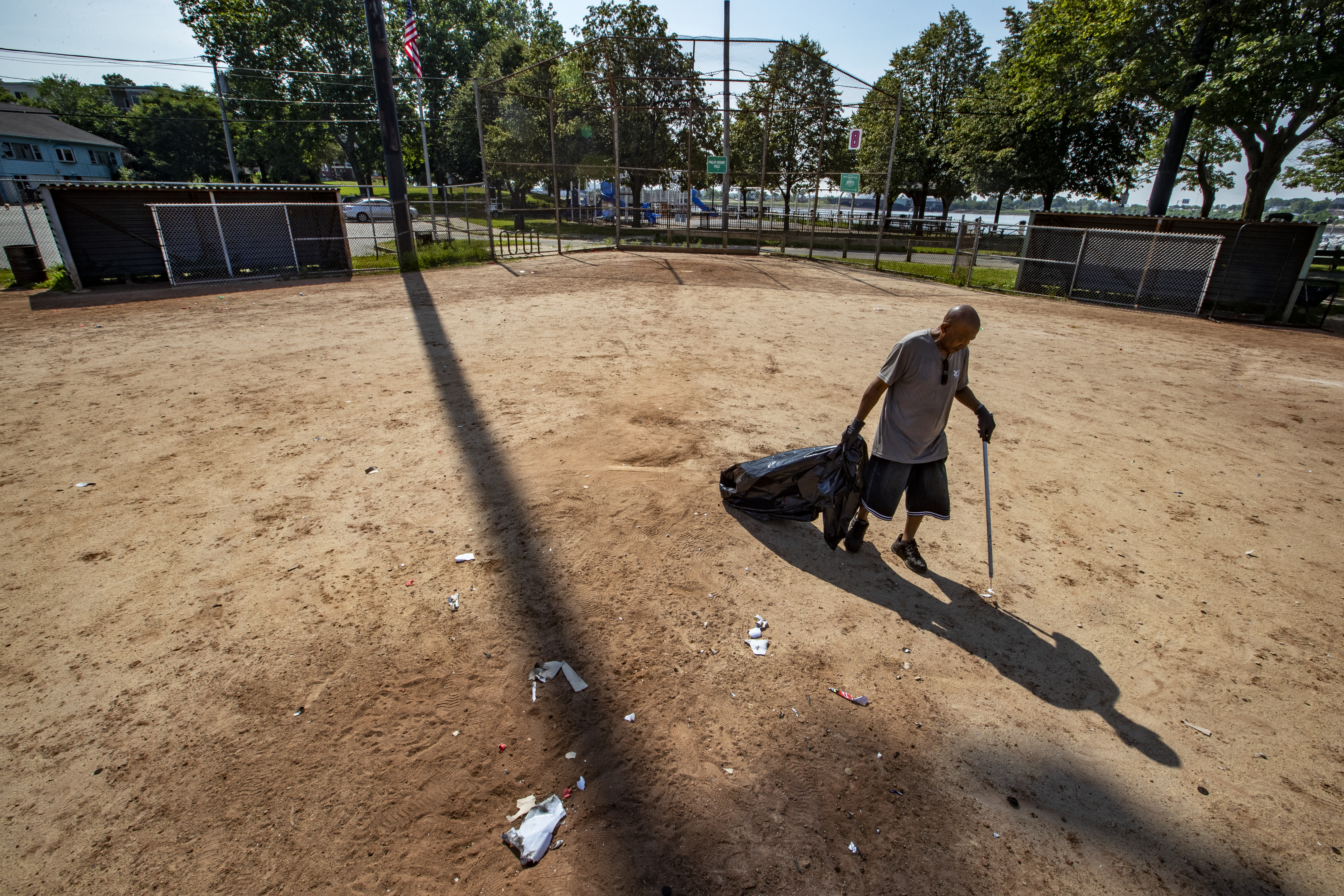Lance Wheeler, a Boston Parks Department foreman, picks up trash and fireworks leftover from Fourth of July celebrations at McConnell Park in Dorchester.