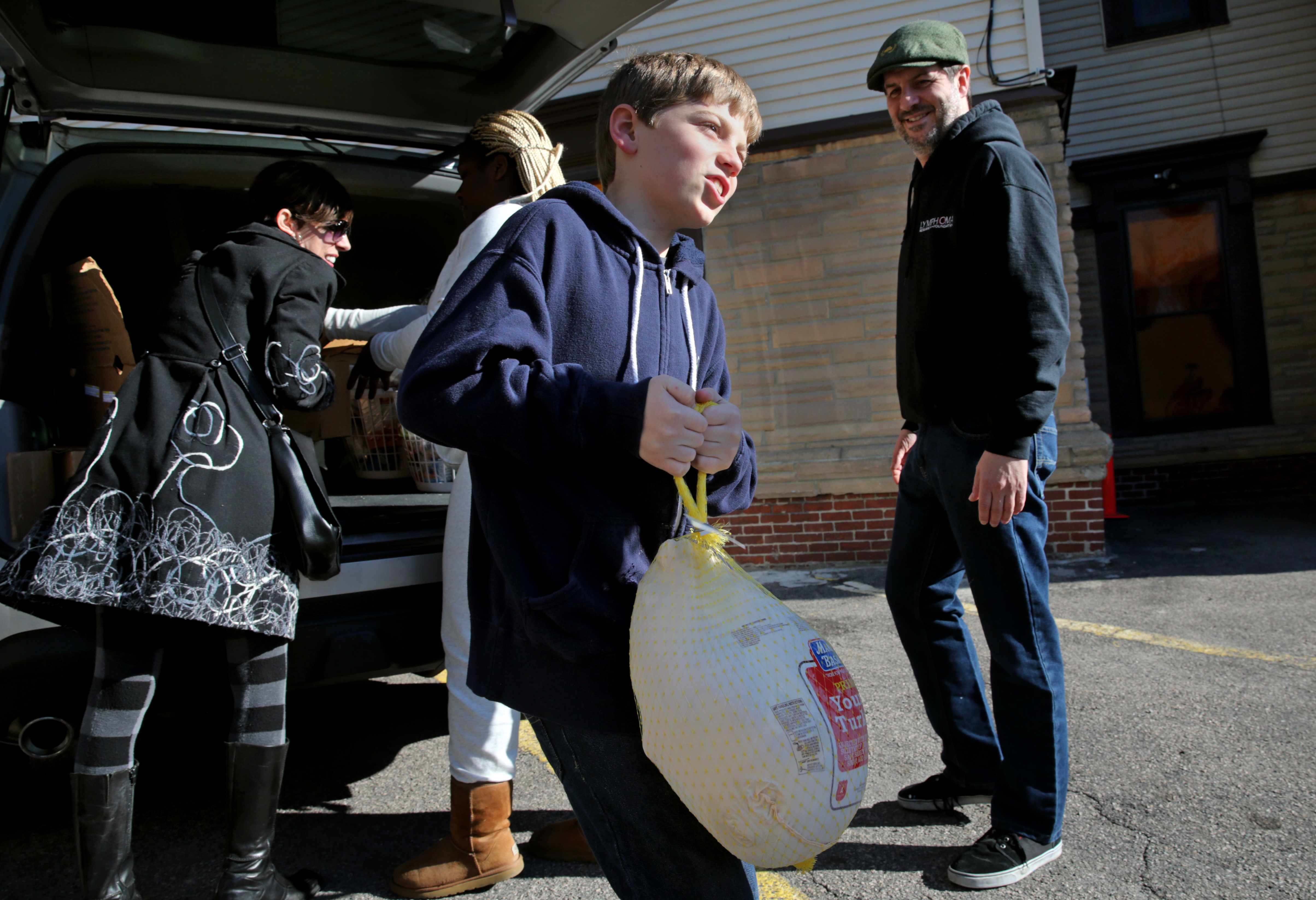 Liam delivered turkeys with his father, Scott Hannon (right) and Hildebrand Family Self-Help Center staff.