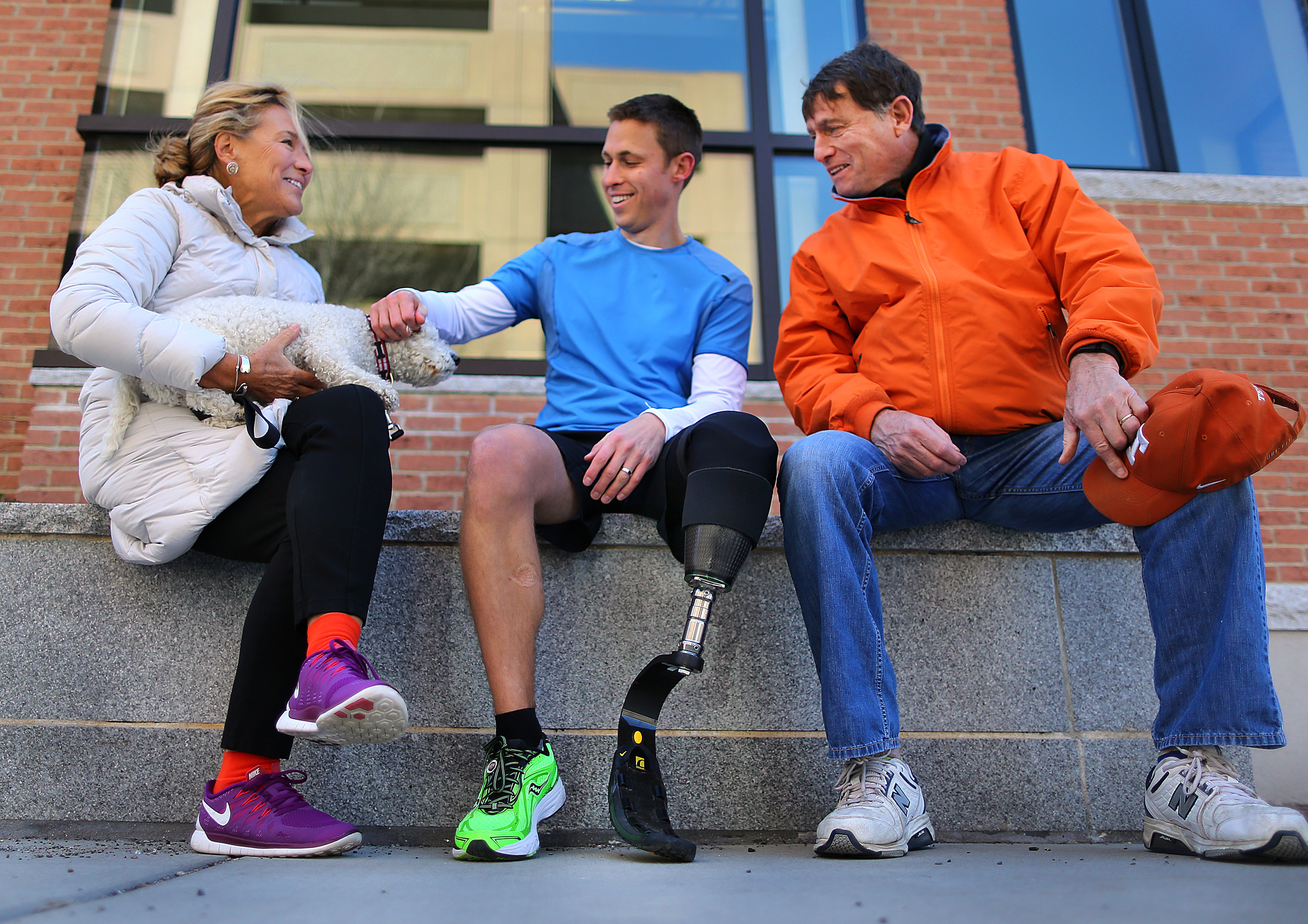 Patrick Downes chatted with his parents, Deborah and Brian, in front of his condominium in Cambridge before going on a training run. The running blade is custom-fit for his left leg.
