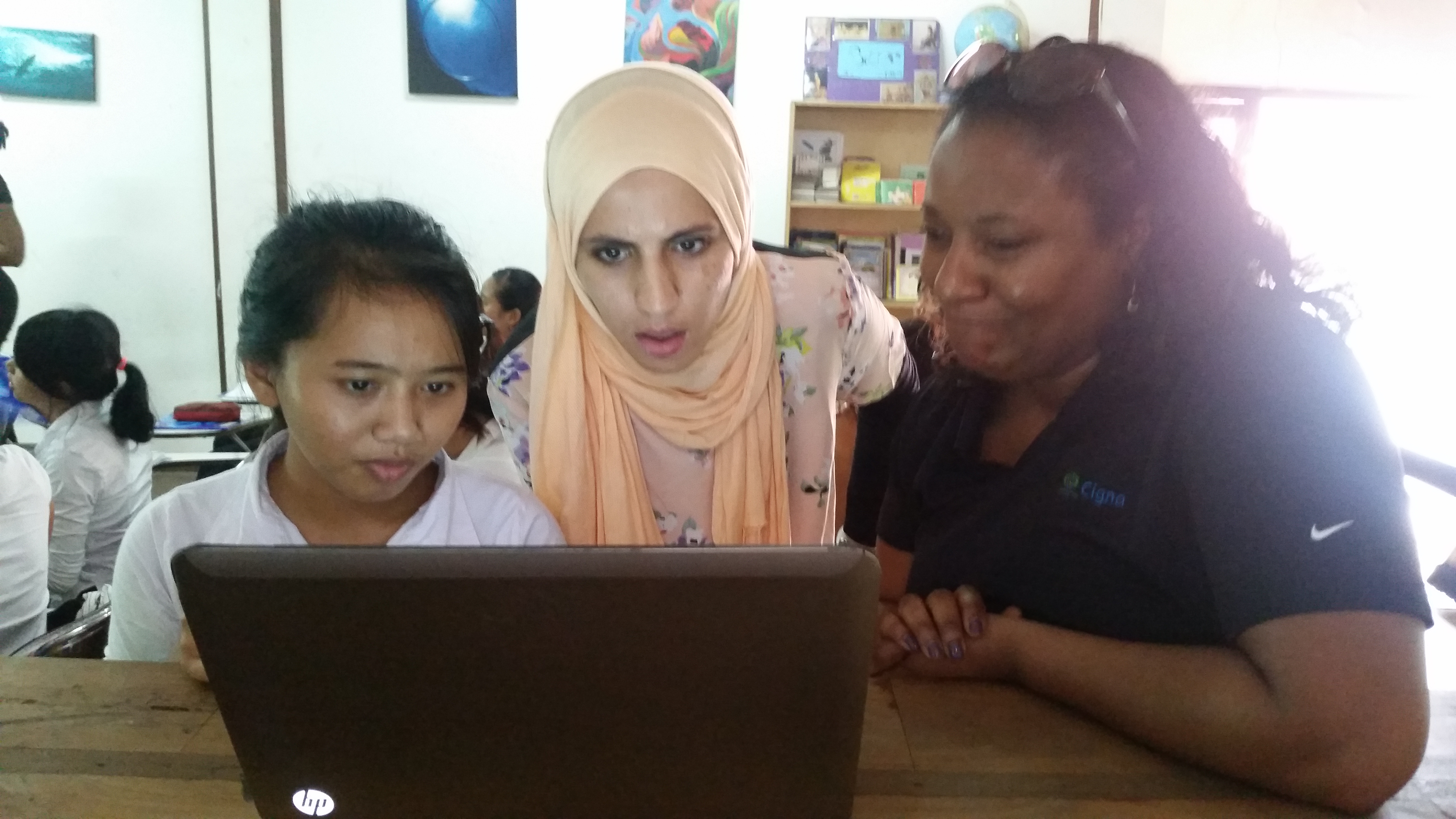 Cigna employee Shatice Collins (right) worked with women on computer skills at ROLE Foundation in Indonesia.