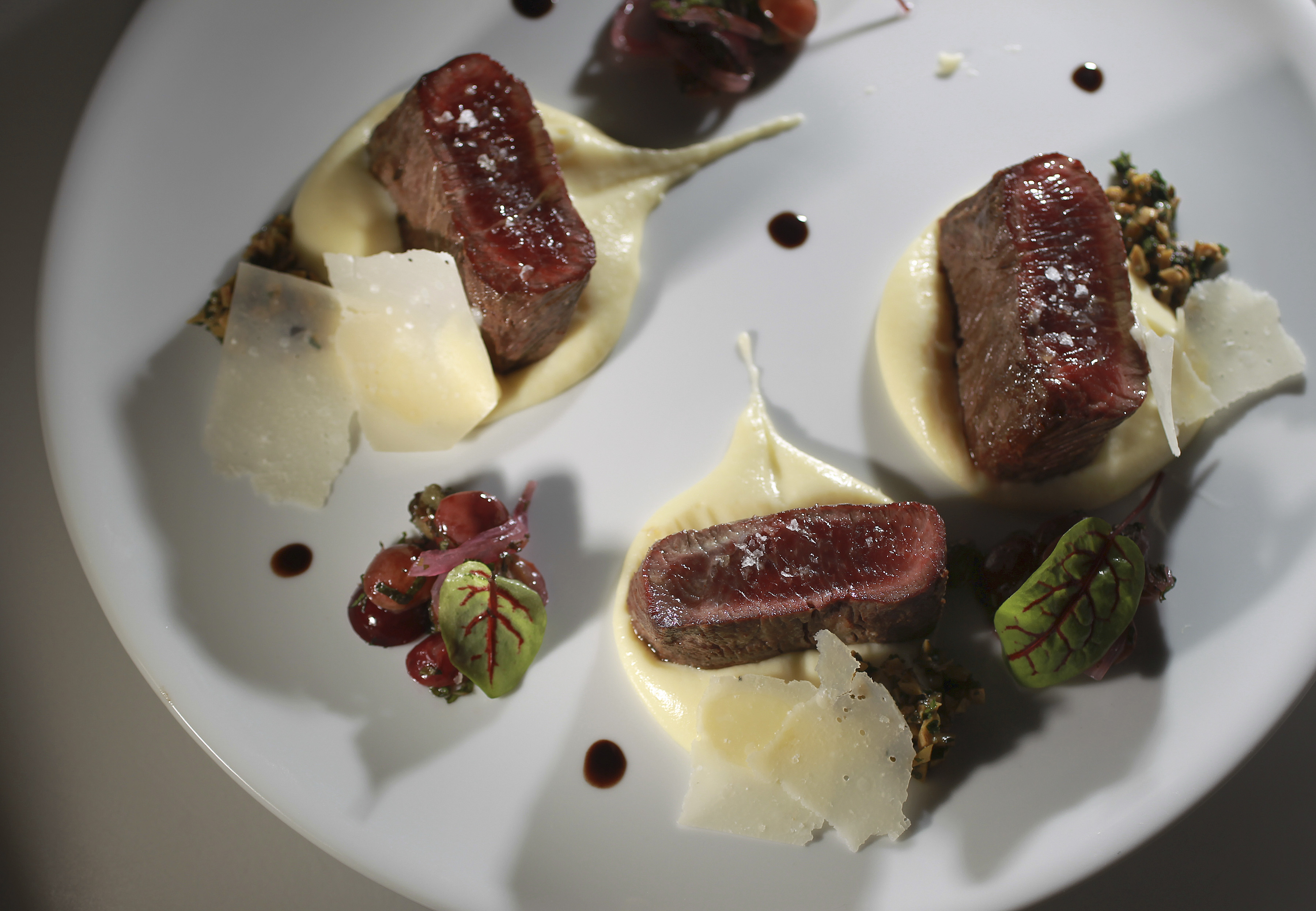Sliced lamb on potato puree.