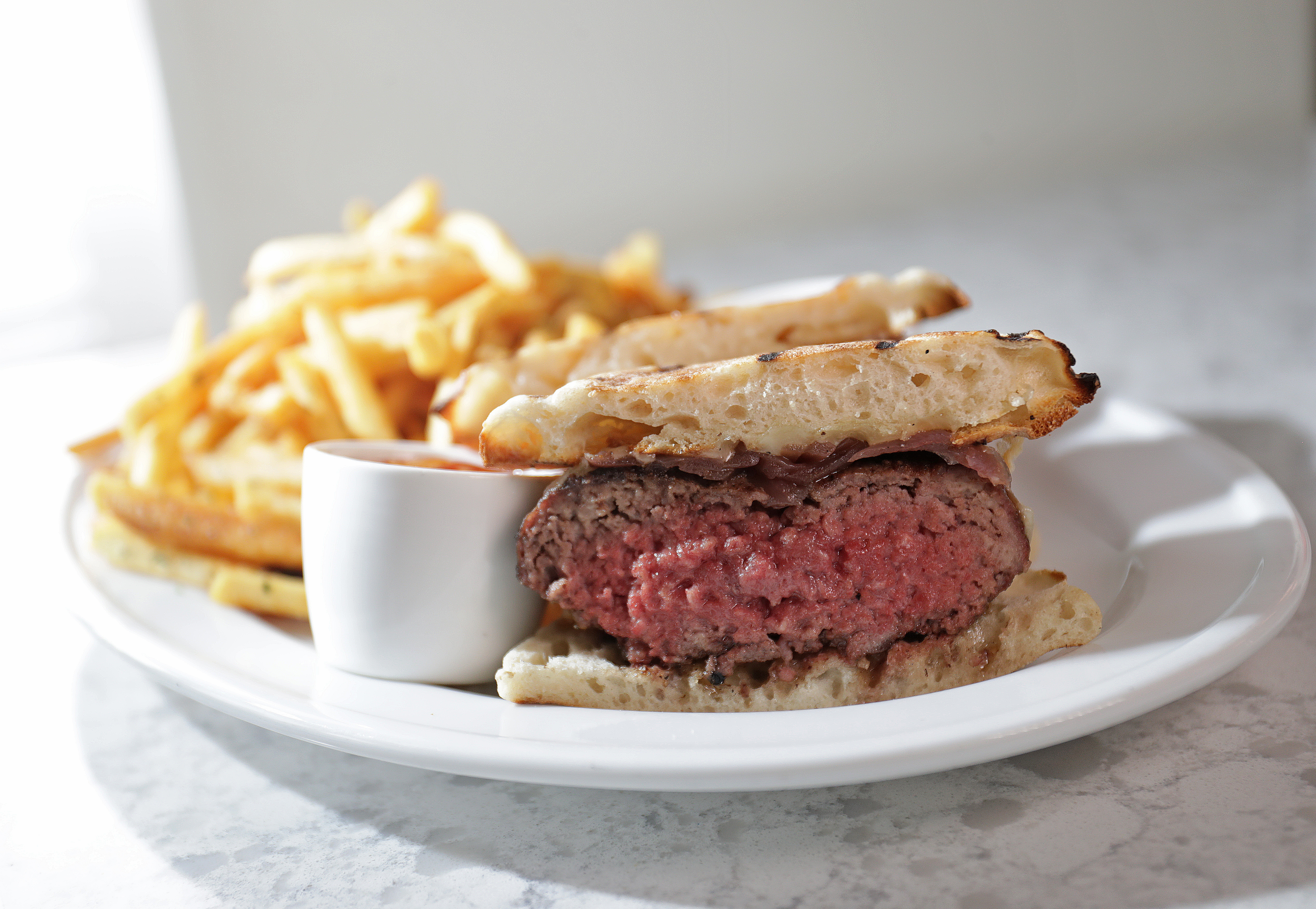 The LoLa burger, with cheddar, onion compote, and foie gras sauce, is served on an English muffin at LoLa 42.