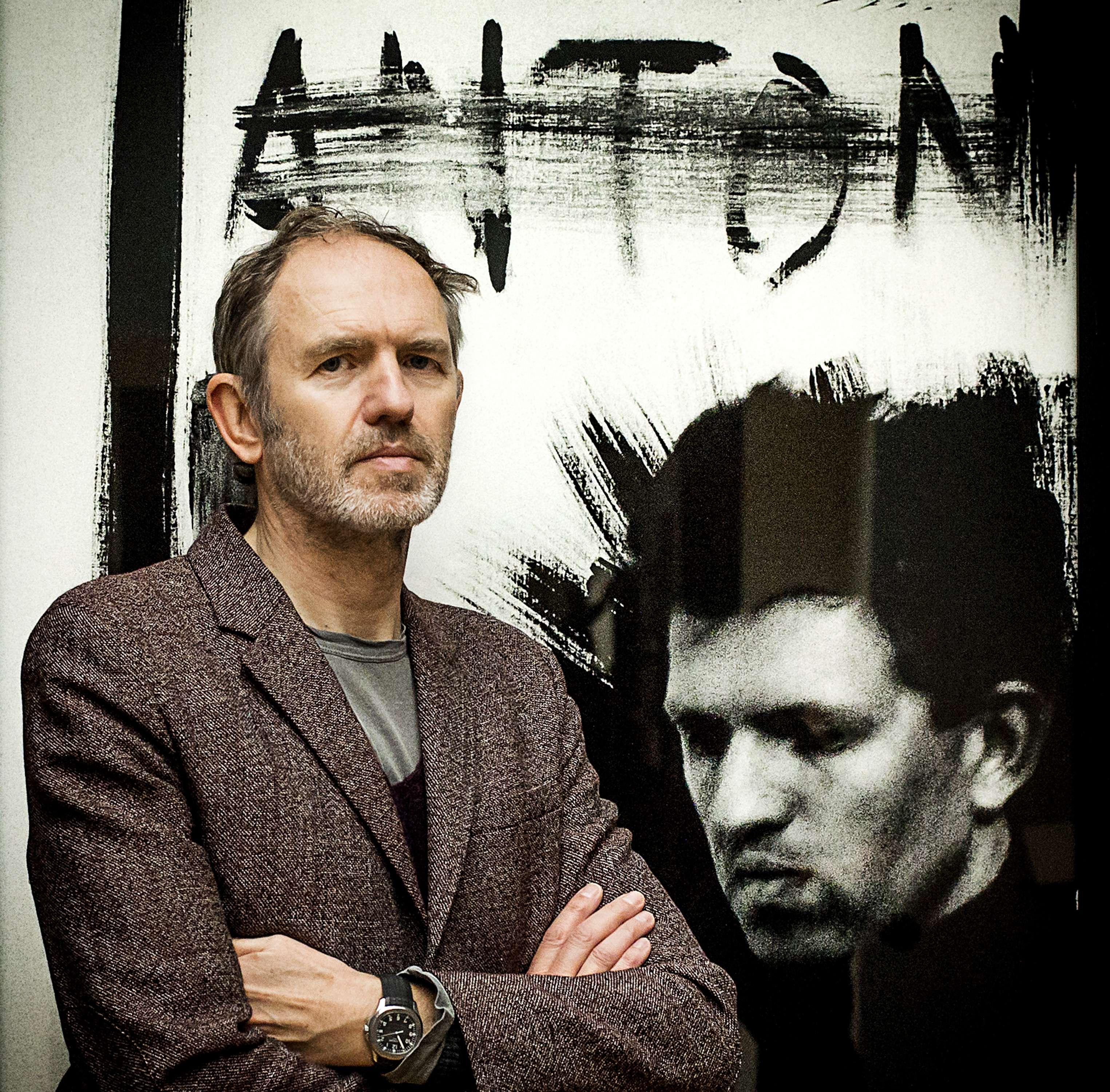 Anton Corbijn in front of a self-portrait at the Gemeentemuseum.