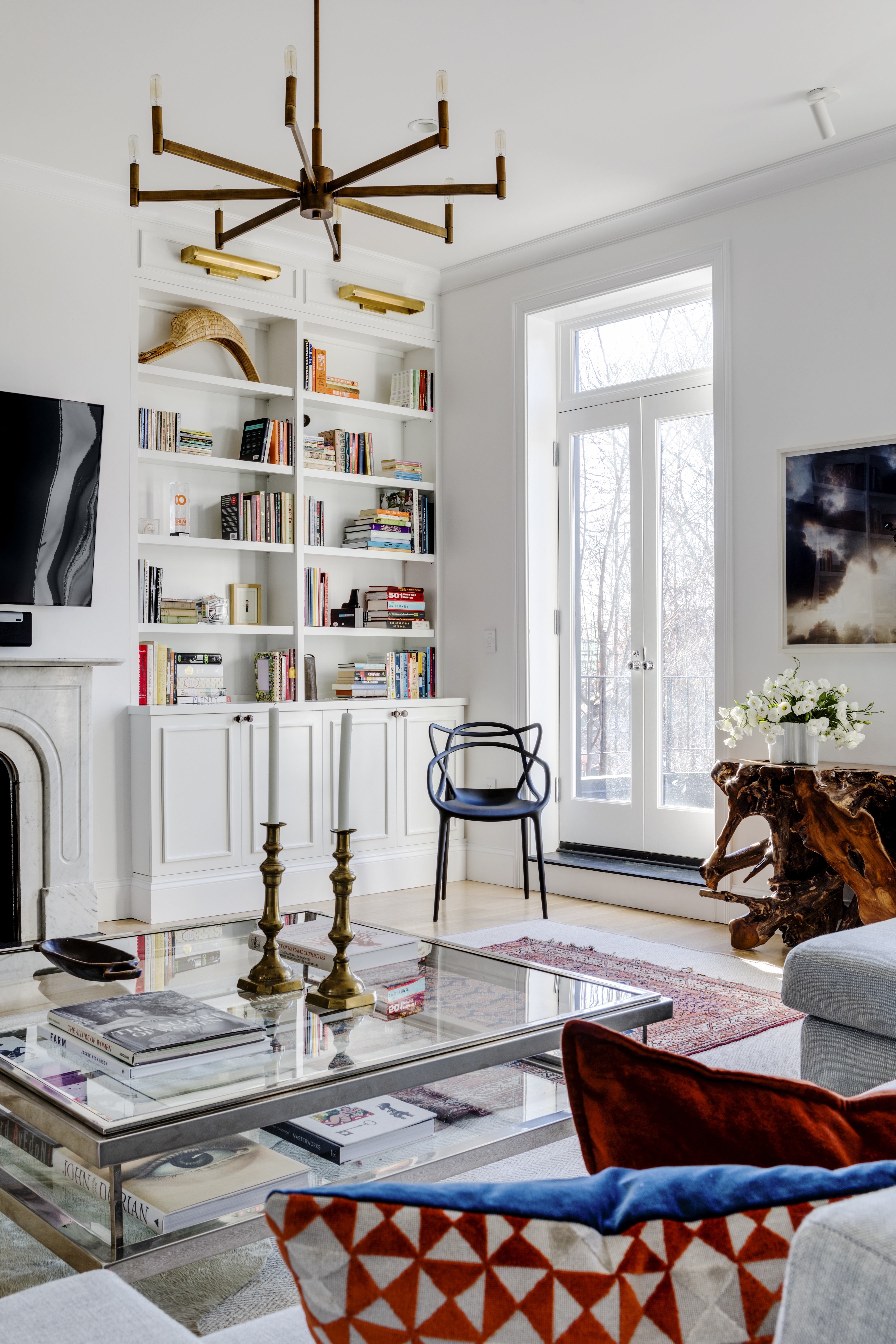 Interior designer Michael Ferzoco designed the built-ins that flank the fireplace in the living room. Brass picture lights add an Old World touch.