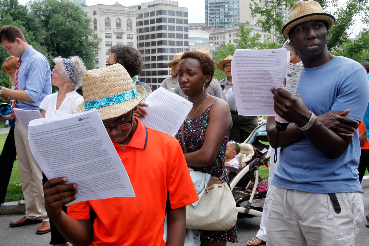 Jean-Paul Antoine, 11, his sister, Genevieve, 16, and father, Richard, 41, all of Washington, D.C., read along with a communal reading of a lecture by Frederick Douglass on Tuesday.