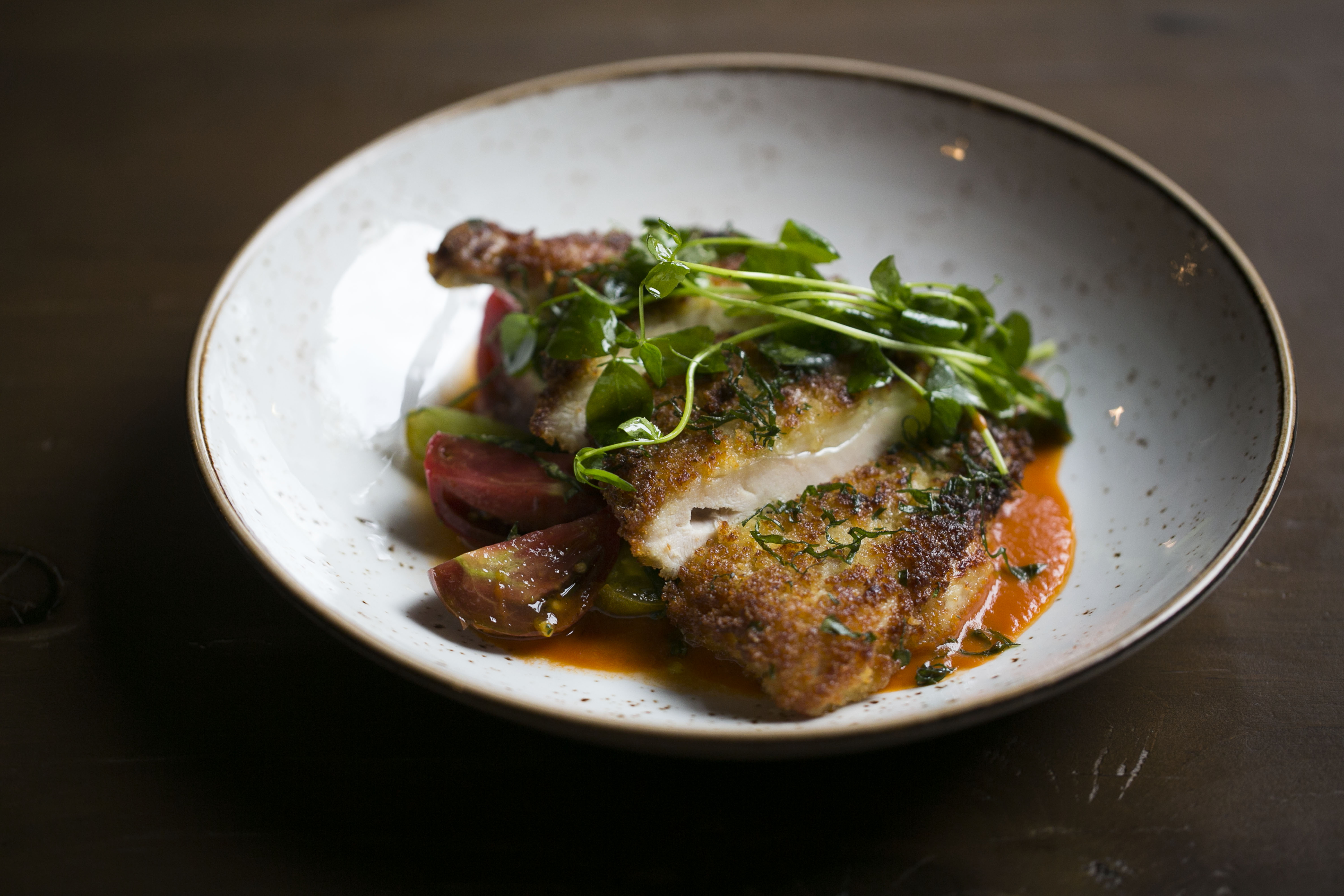 Chicken cutlet with tomato salad over a tomato-basil sauce.
