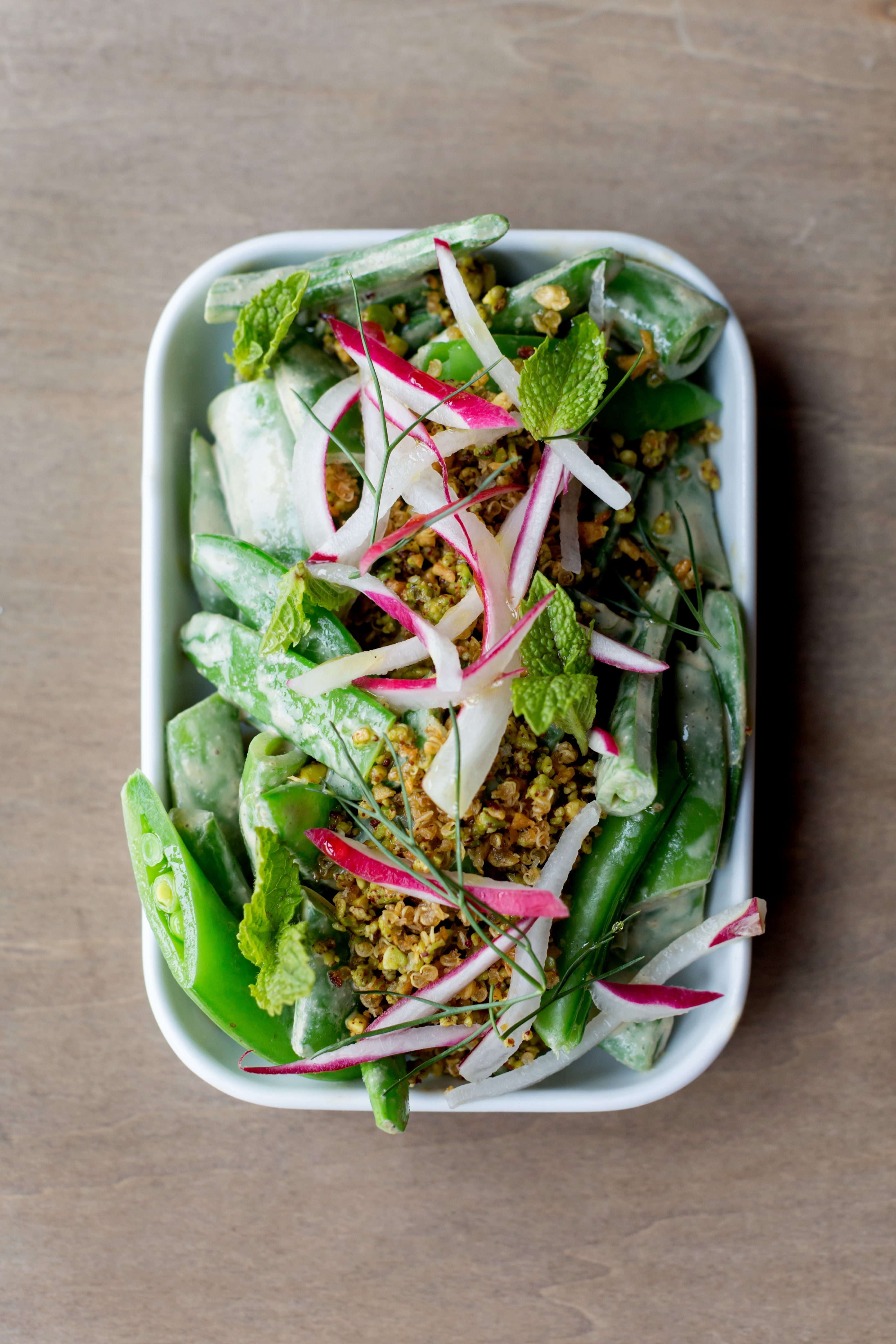 Spring onions and a sugar snap pea, quinoa, and radish dish at Sarma.