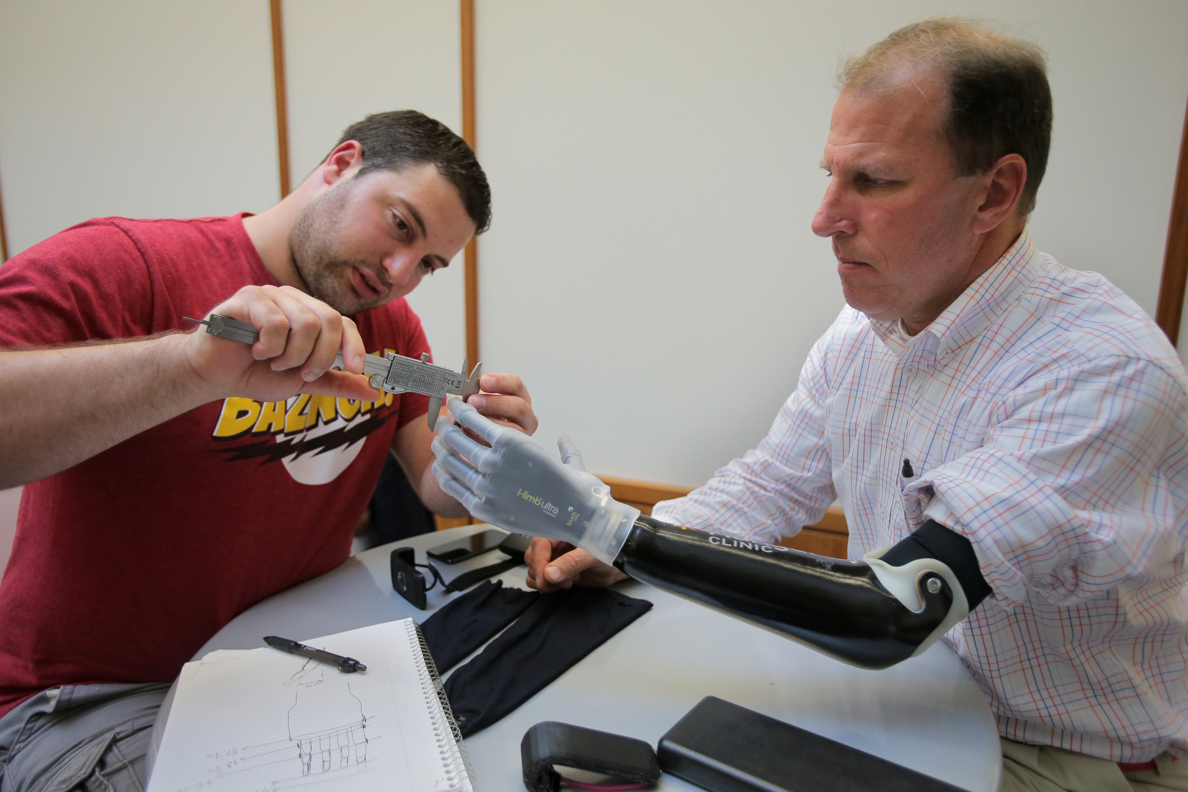 Ioannis Smanis measured Mike Benning’s prosthetic arm.