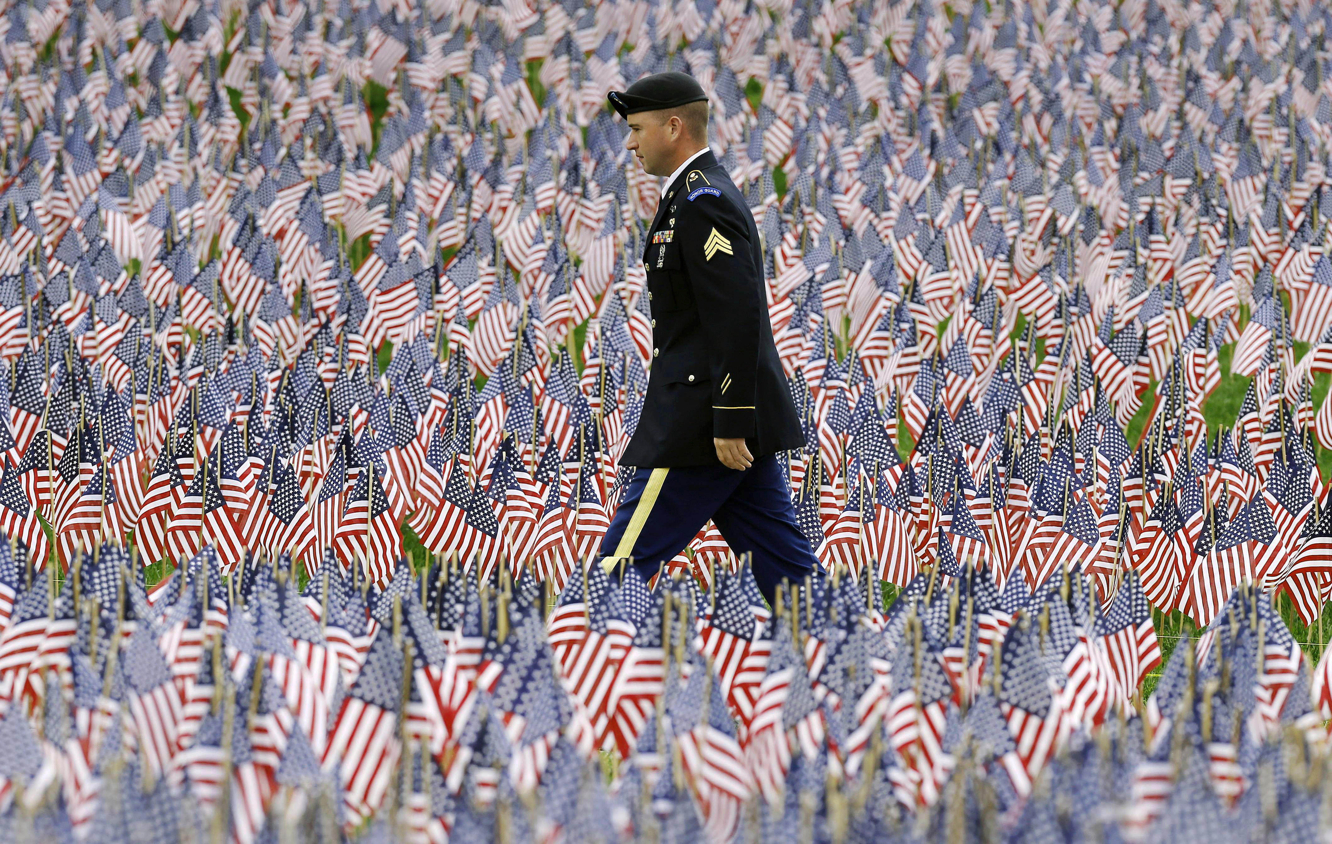 A soldier walked on a path through the flag garden.
