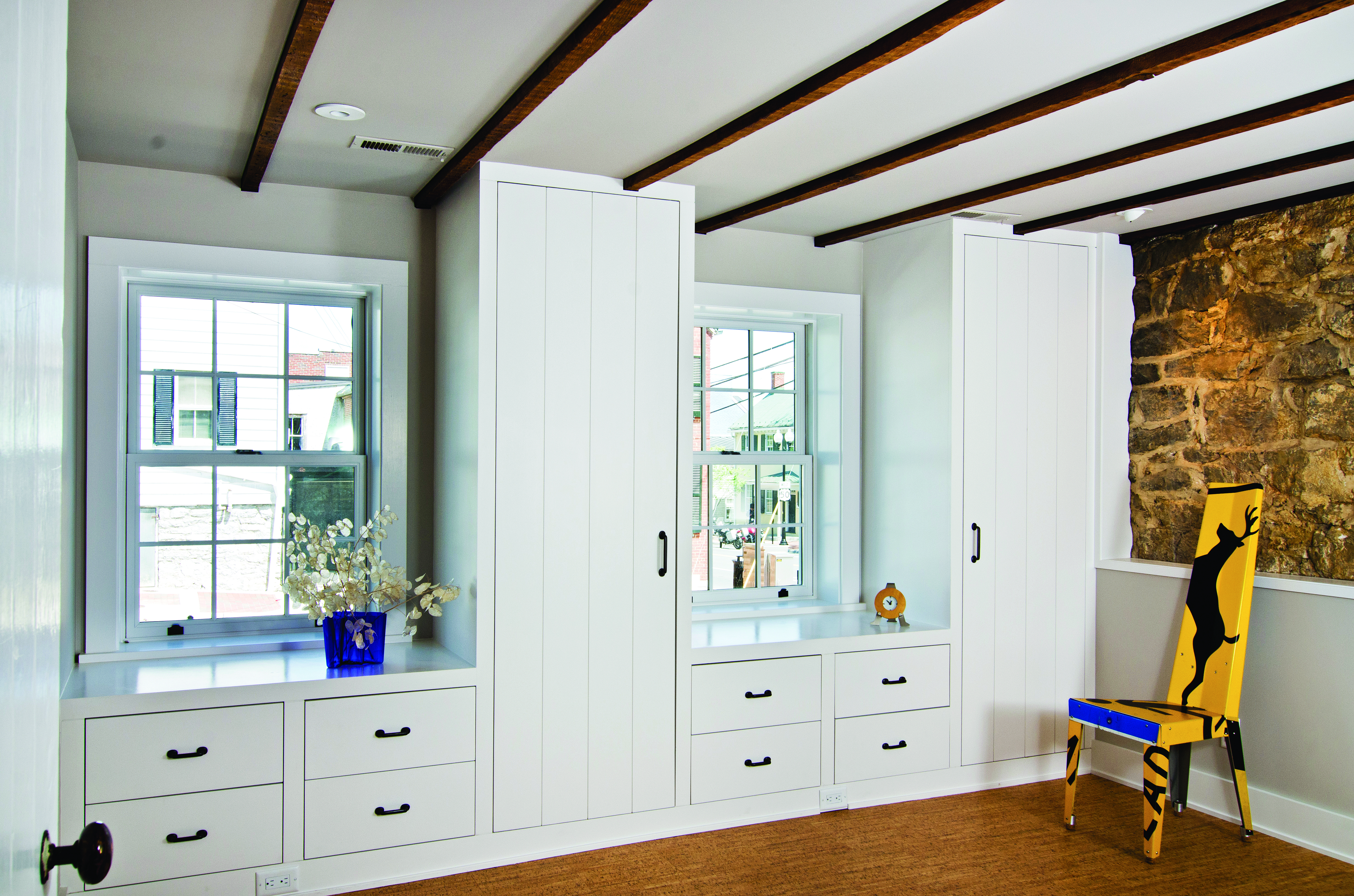 Custom built drawers and cabinets in a bedroom replace dressers or closets.