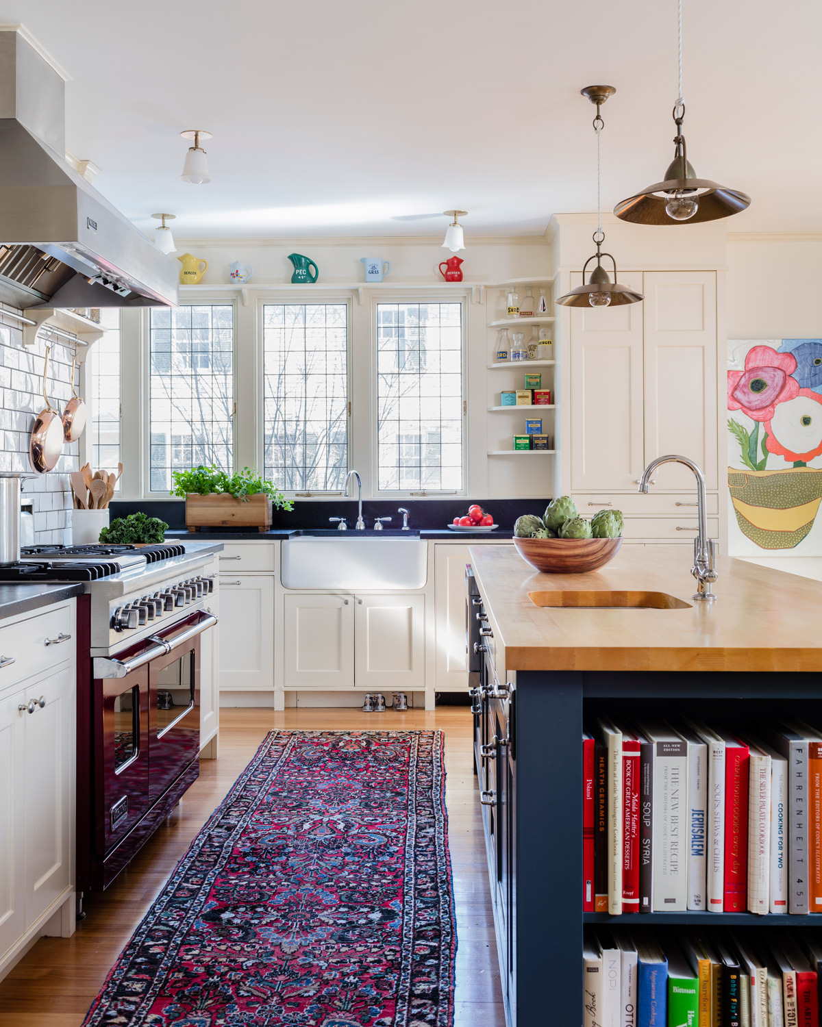 Foot pedals control the water at the kitchen sink, and the homeowners’ colorful pottery collection is displayed above. The poppy painting, from Jules Place, is by Rockport artist Karen Tusinski.