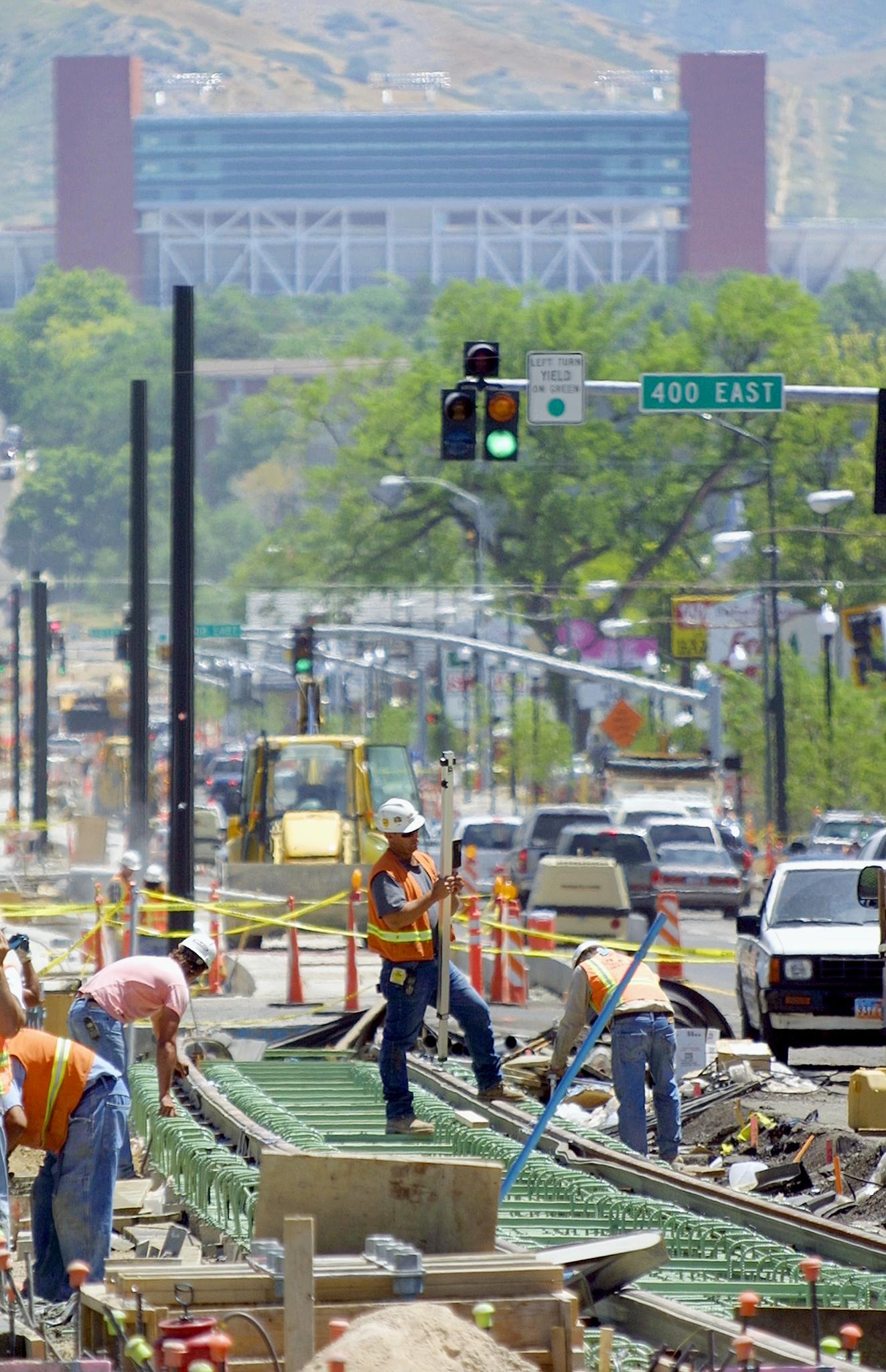 Construction workers build a section of the light rail system that would serve the Olympics.