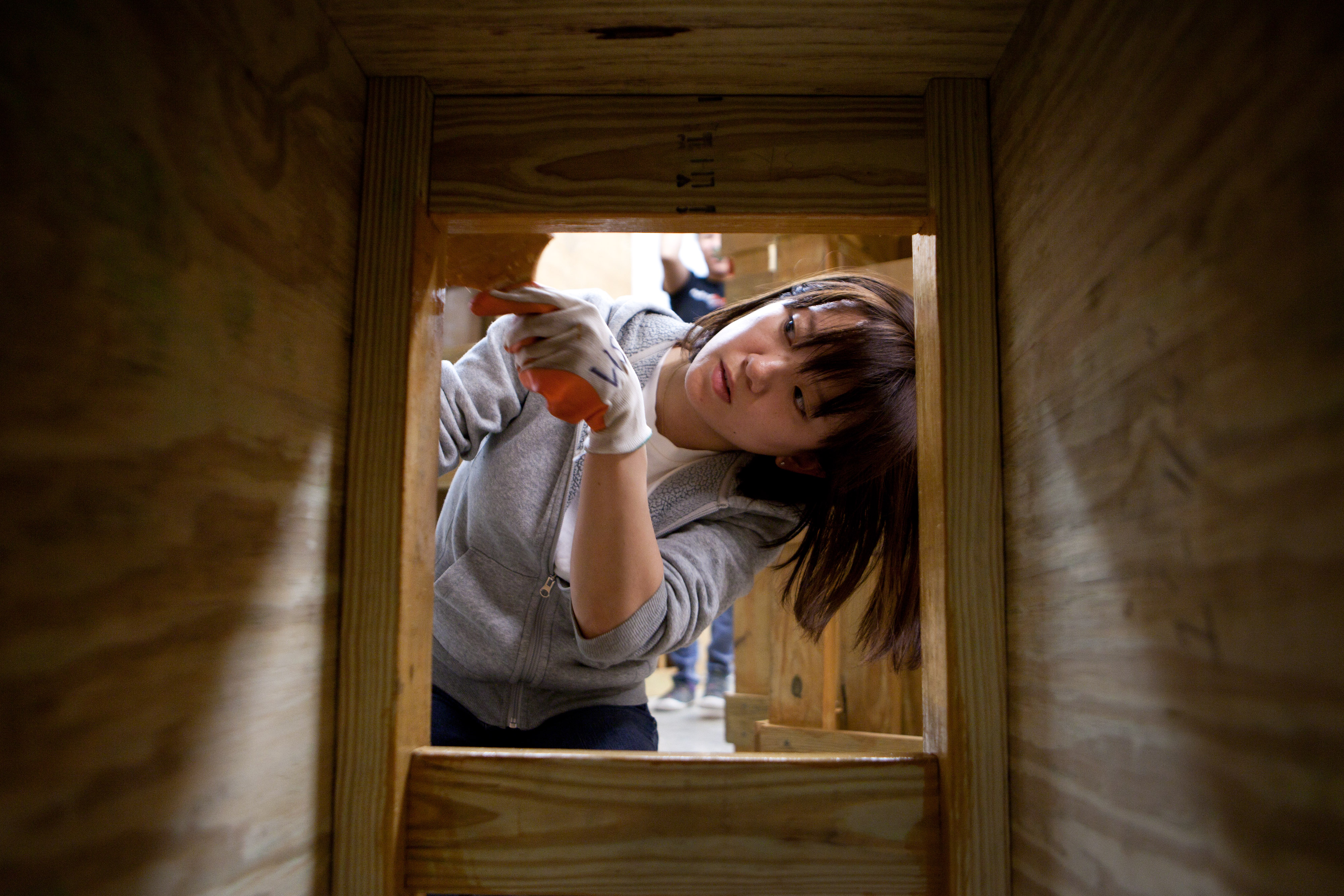 Boston Architectural College student Lisa Ishihara paints movable seats that will be part of the Parkolation Project’s parklet.