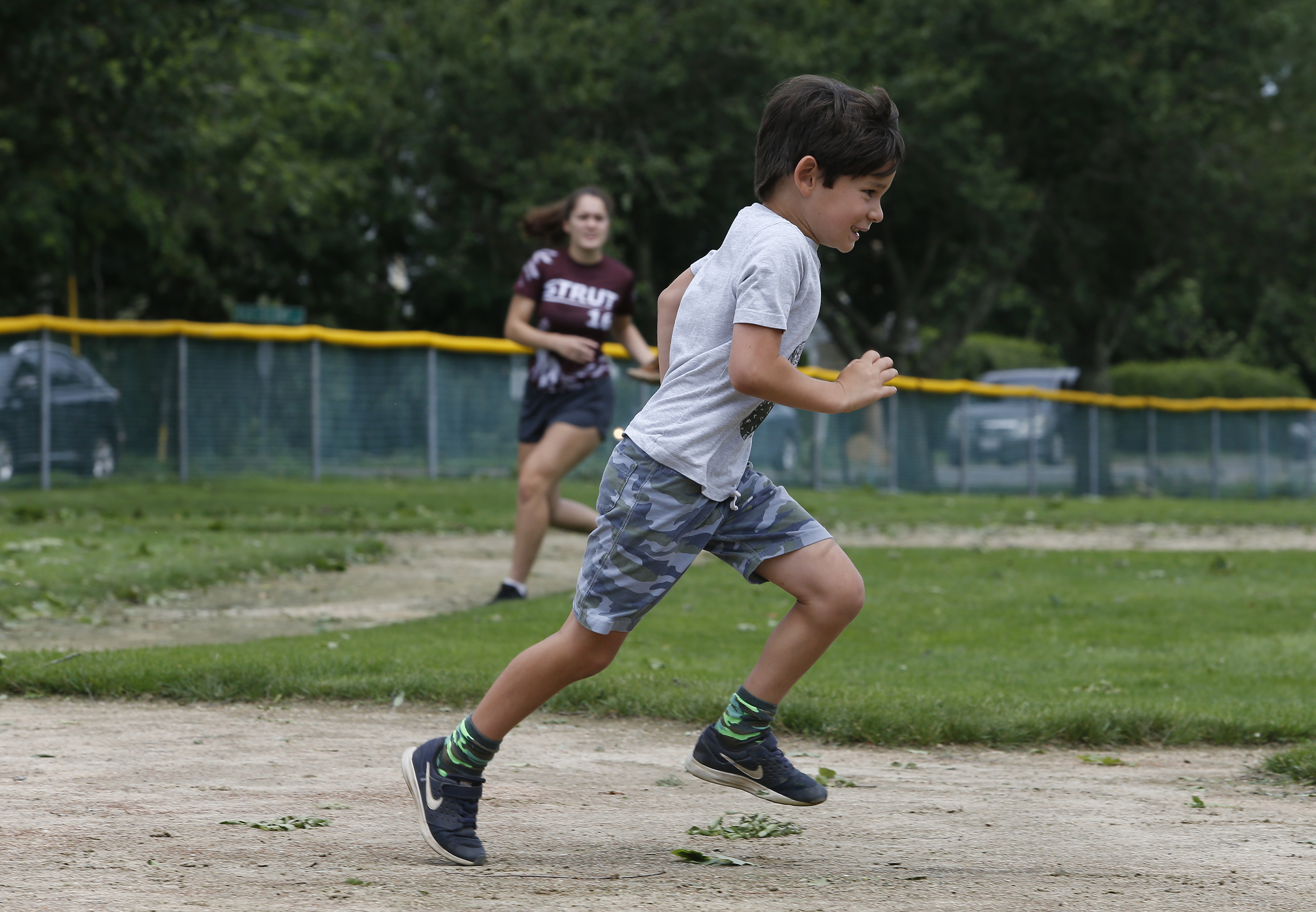 The Earls family made the best of it in Harwich, clearing debris off a ball field and playing a game. Andre Earls ran the bases while Tabitha Earls was behind him.